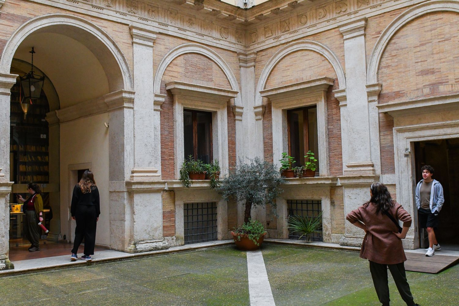 Elegant arched colonnade in a Renaissance-style courtyard with stone architecture.