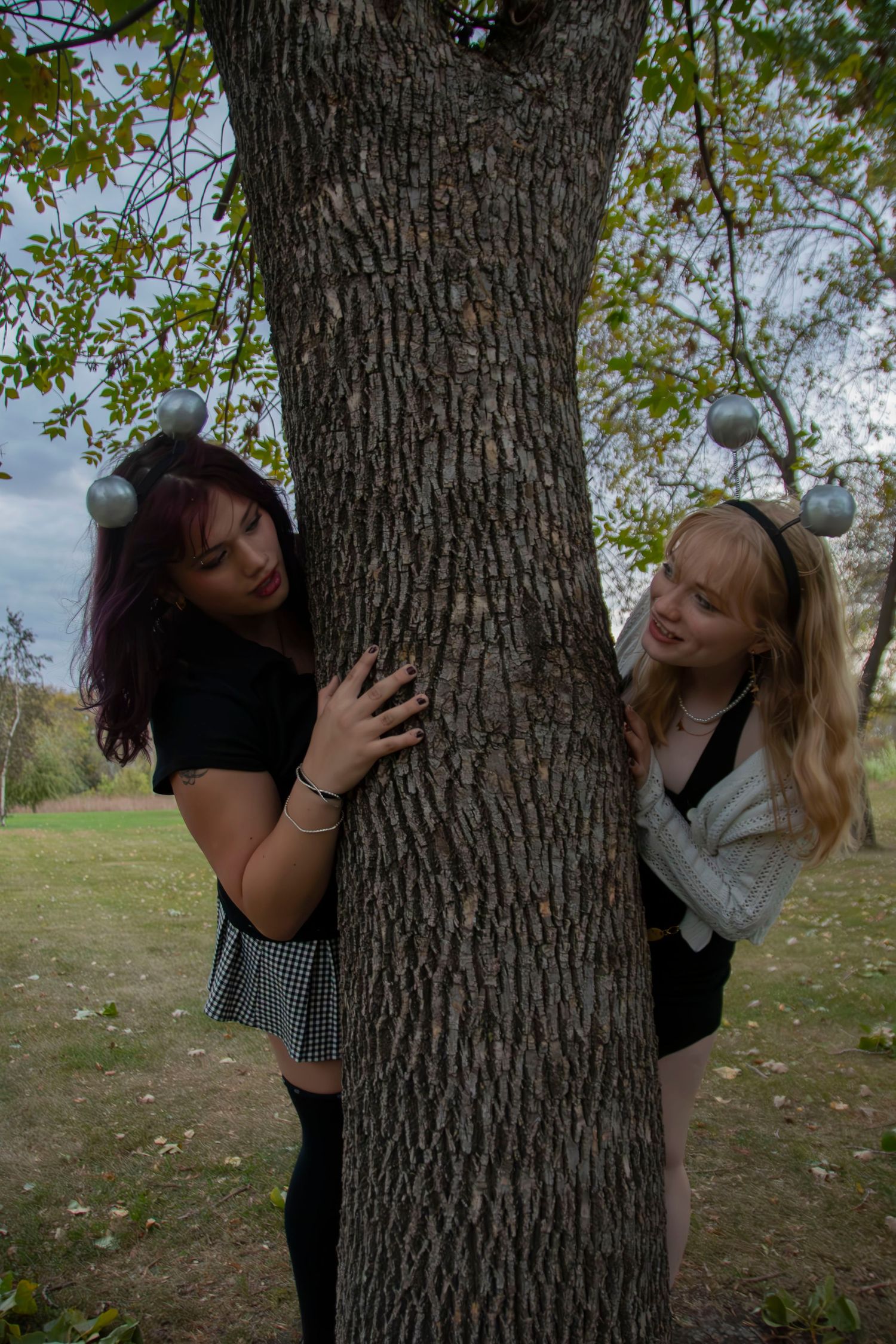 Two people playfully pose against a large tree trunk in a series of five connected photos in an outdoor setting.
