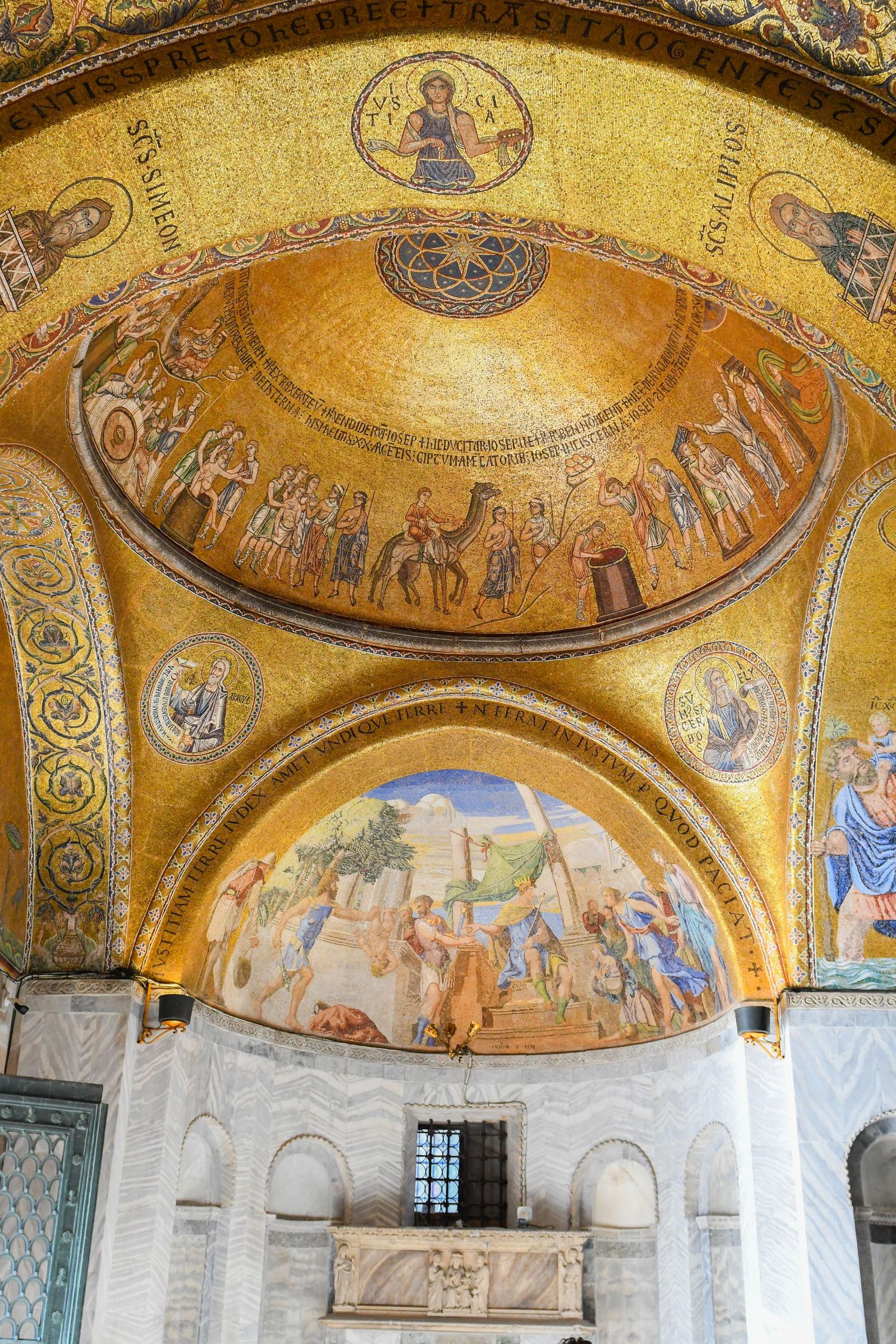 Golden Byzantine mosaic adorns the dome ceiling of a historic church with religious artwork.
