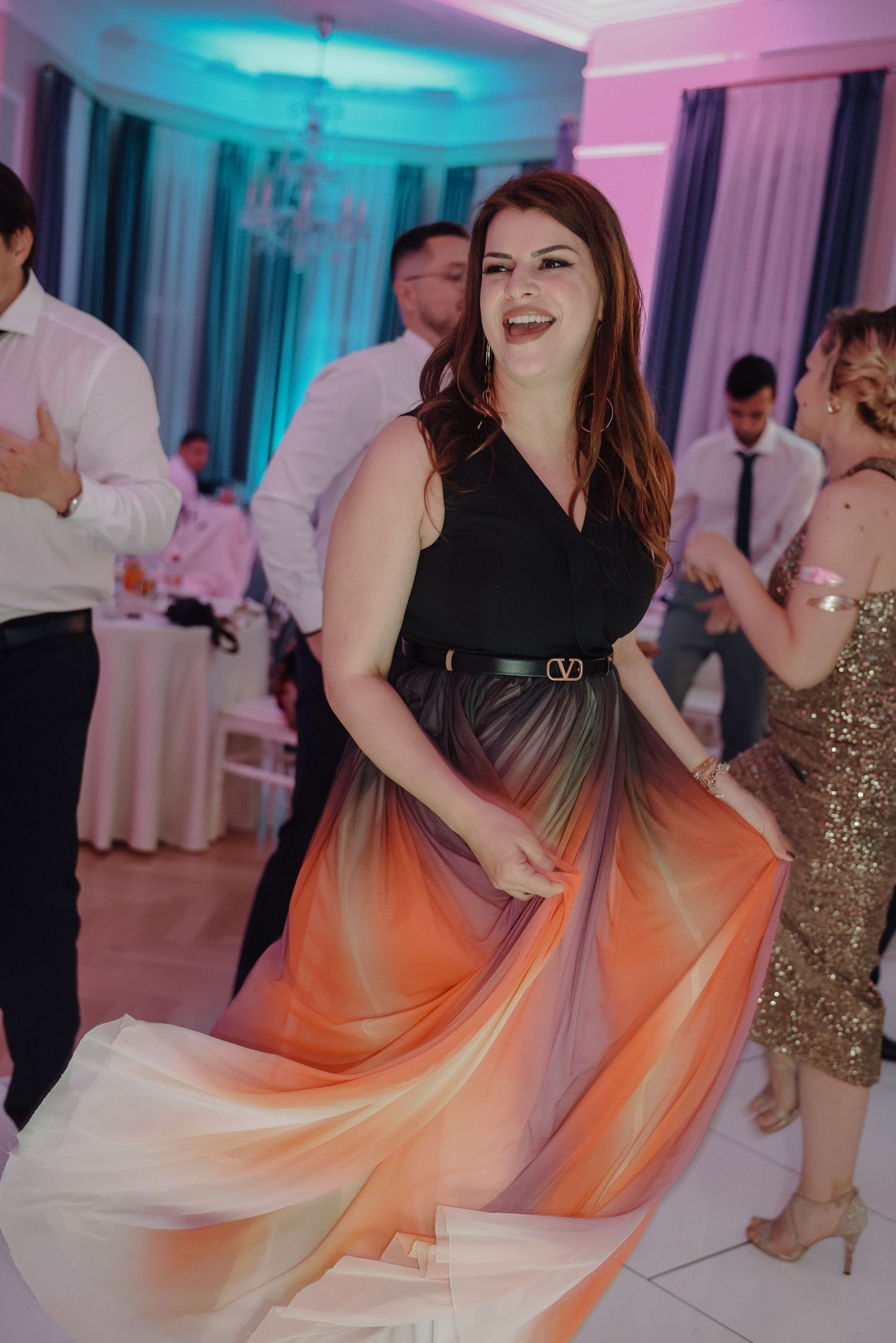 Wedding reception dance floor illuminated with vibrant blue and orange lighting effects.