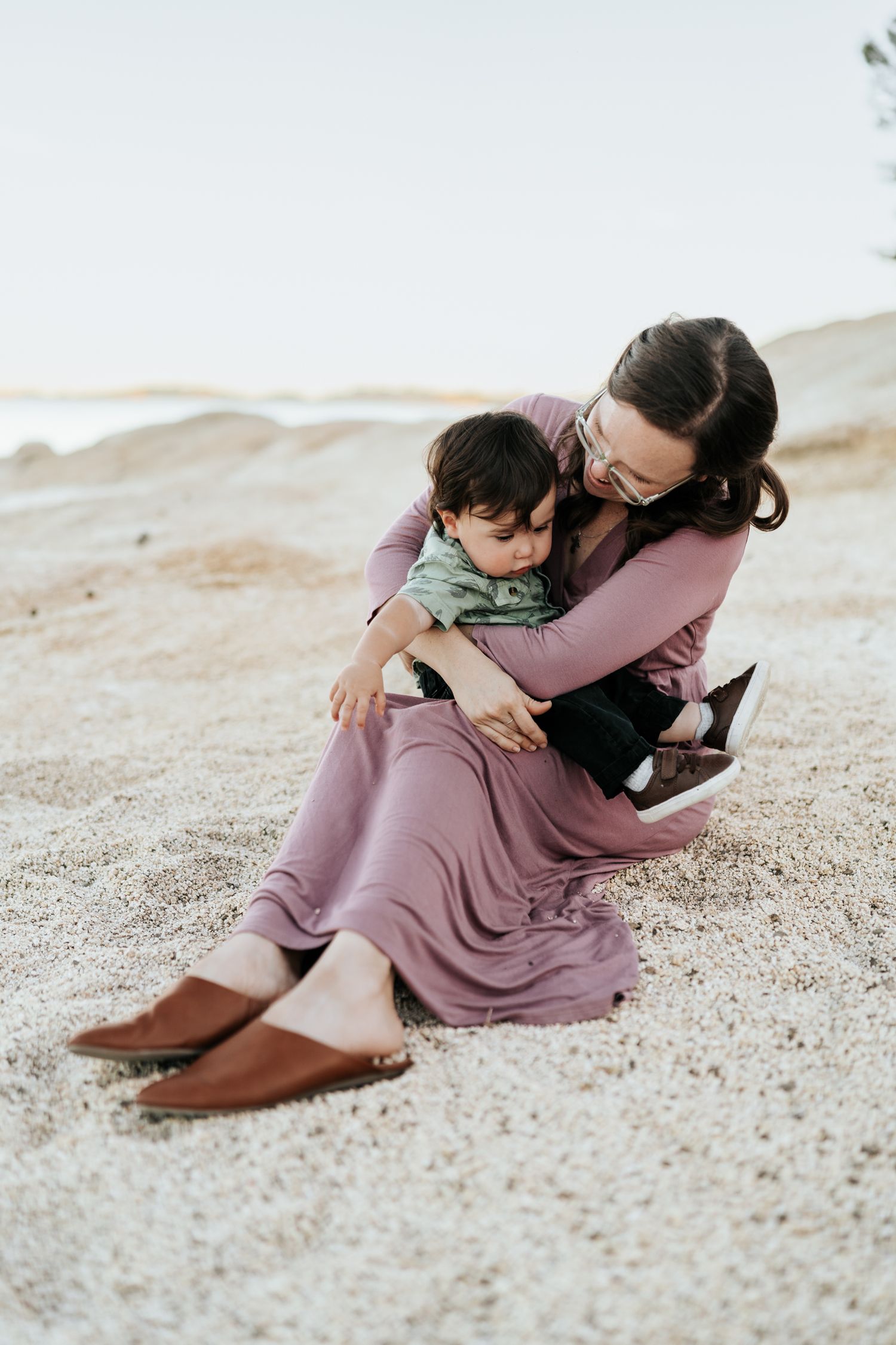 Sweet candid moments of togetherness captured on a sandy beach in soft natural lighting.