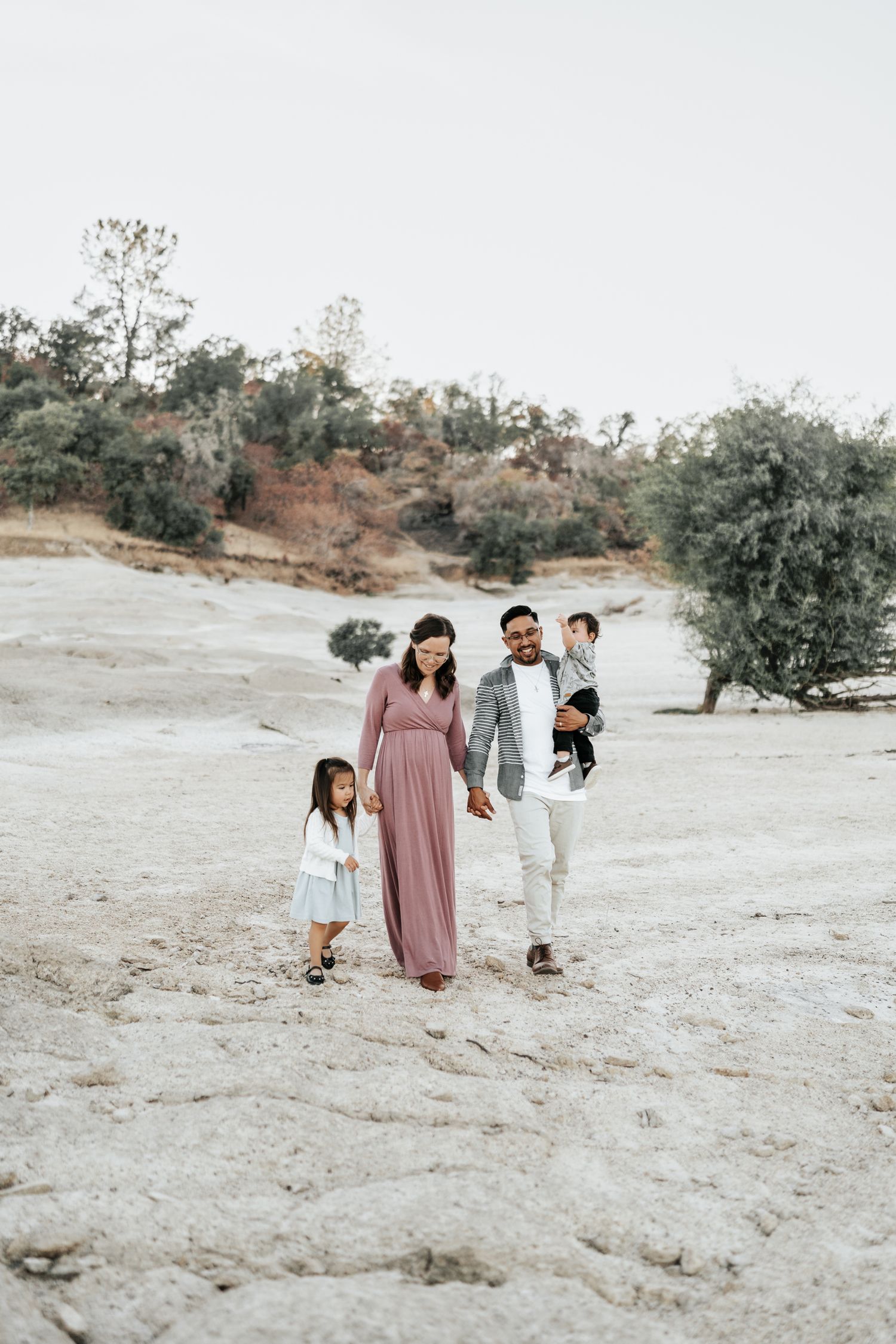Group enjoying time together on a rocky terrain with scattered trees in the background.