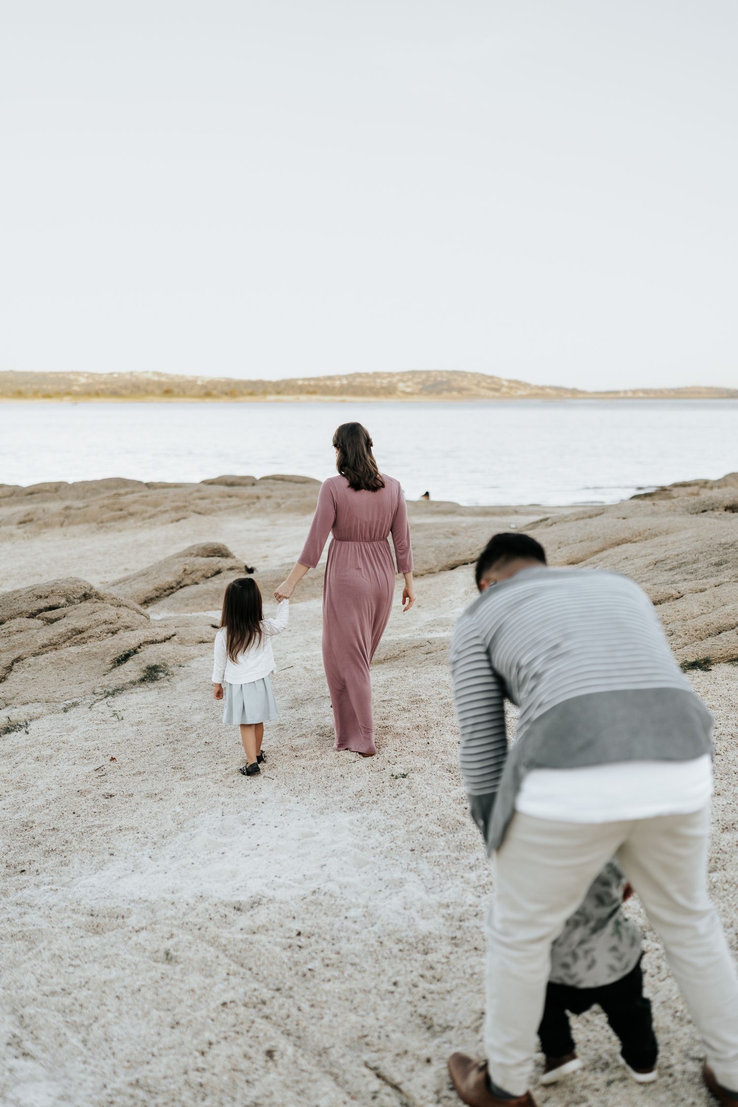 People walking and exploring a sandy desert landscape under bright skies.