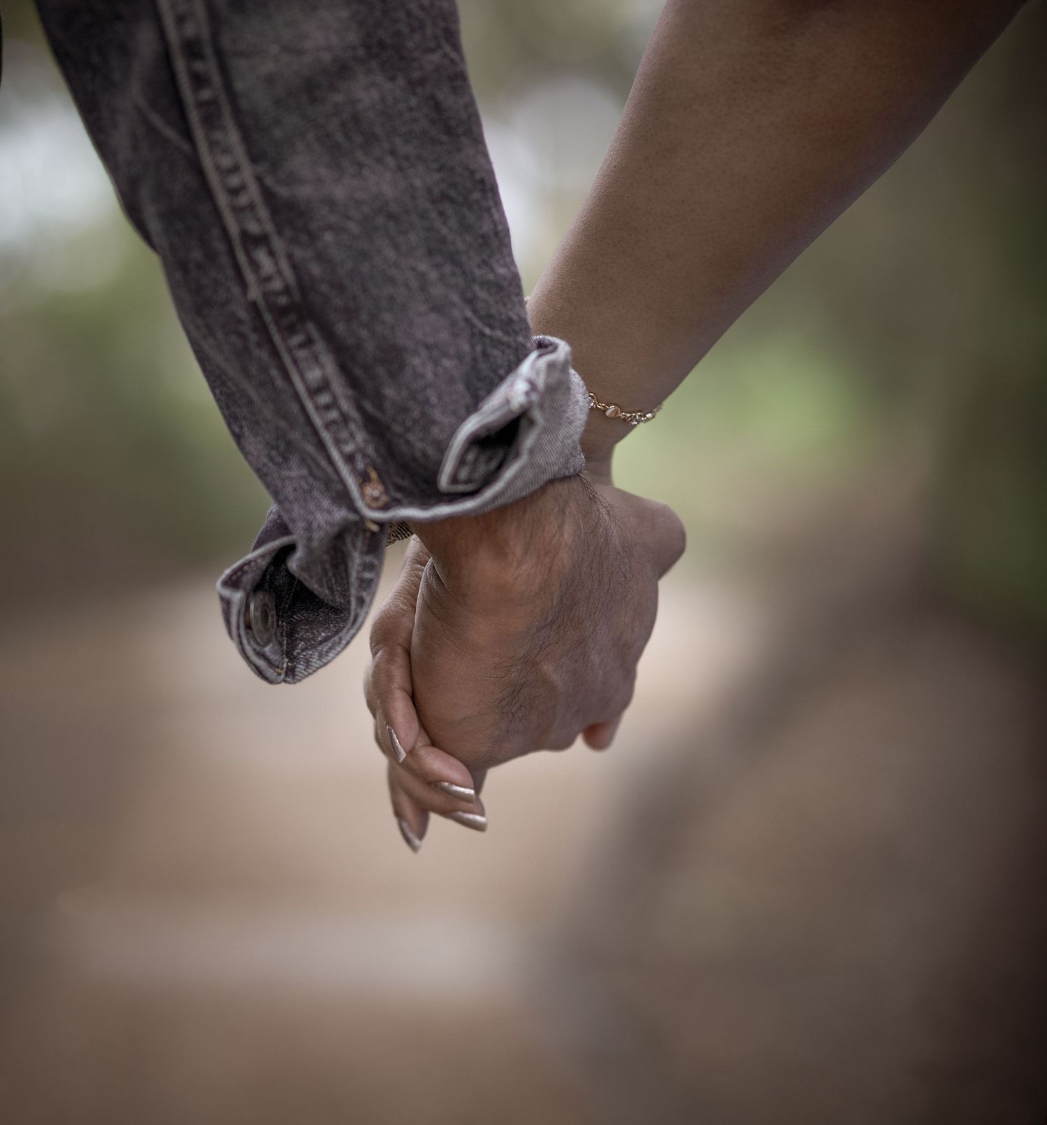Close-up of intertwined hands showing an engagement moment.
