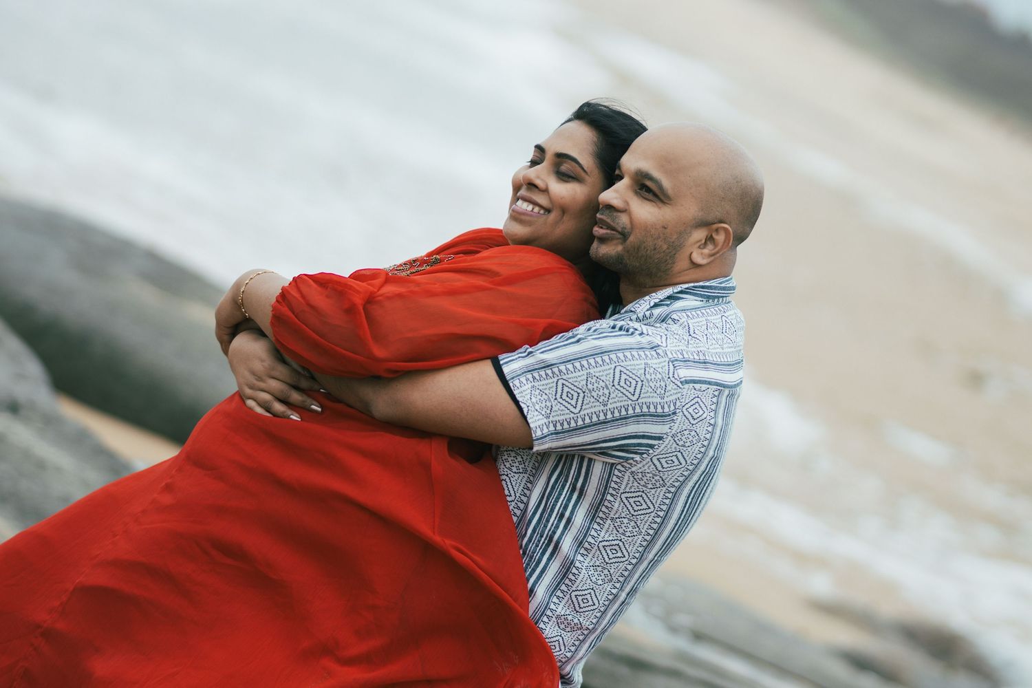 Candid romantic moments captured during beach engagement photoshoot.