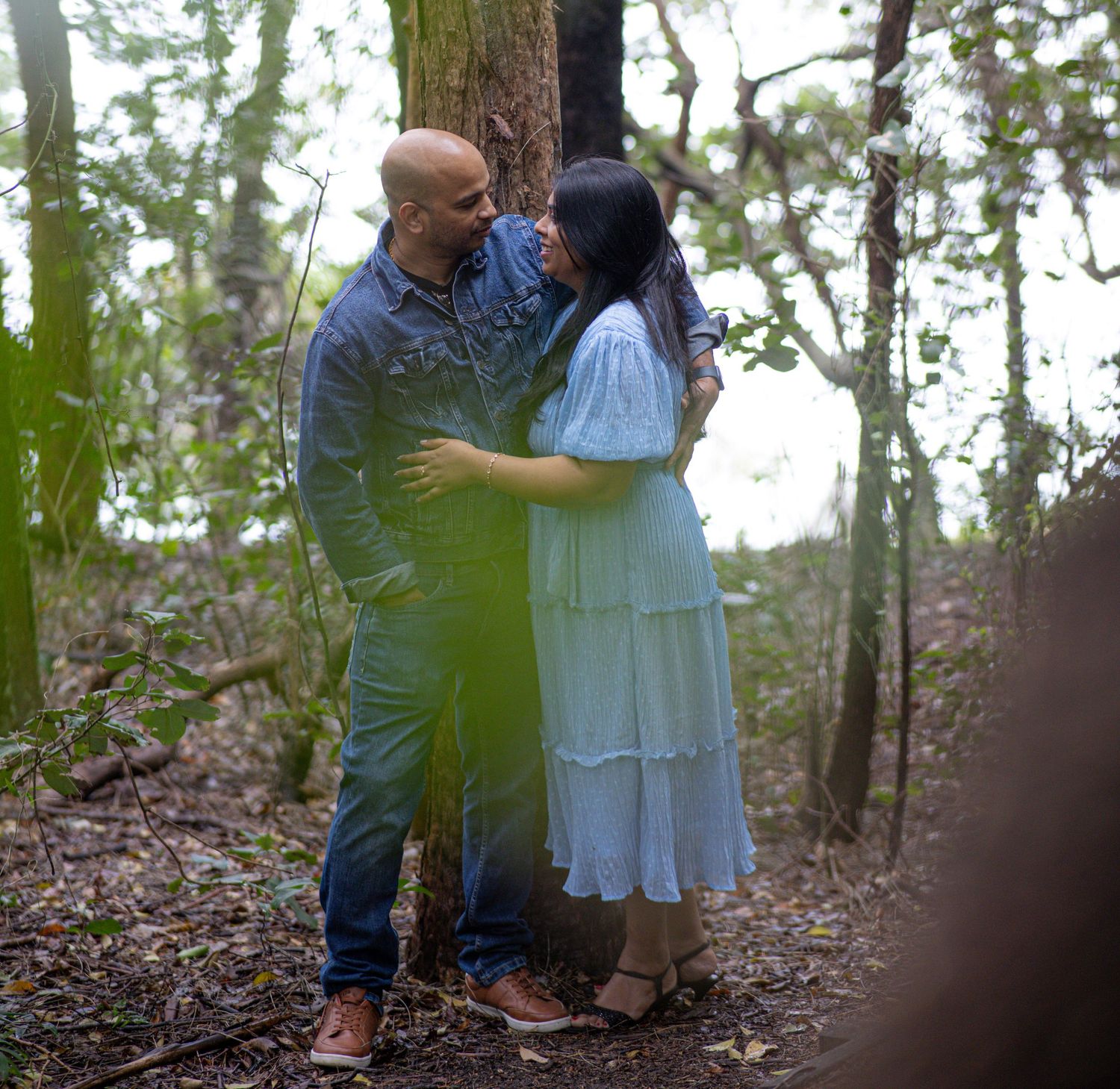 Artistic low-angle photo series of a couple sharing tender moments among tall trees.