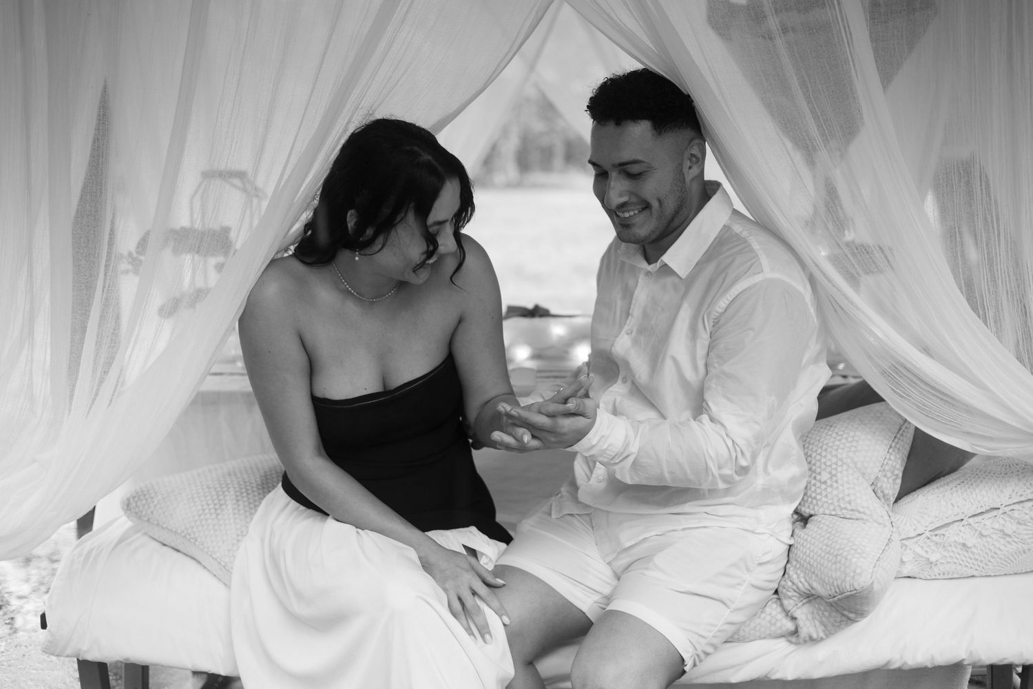 Couple sharing sweet moments under billowing white canopy.