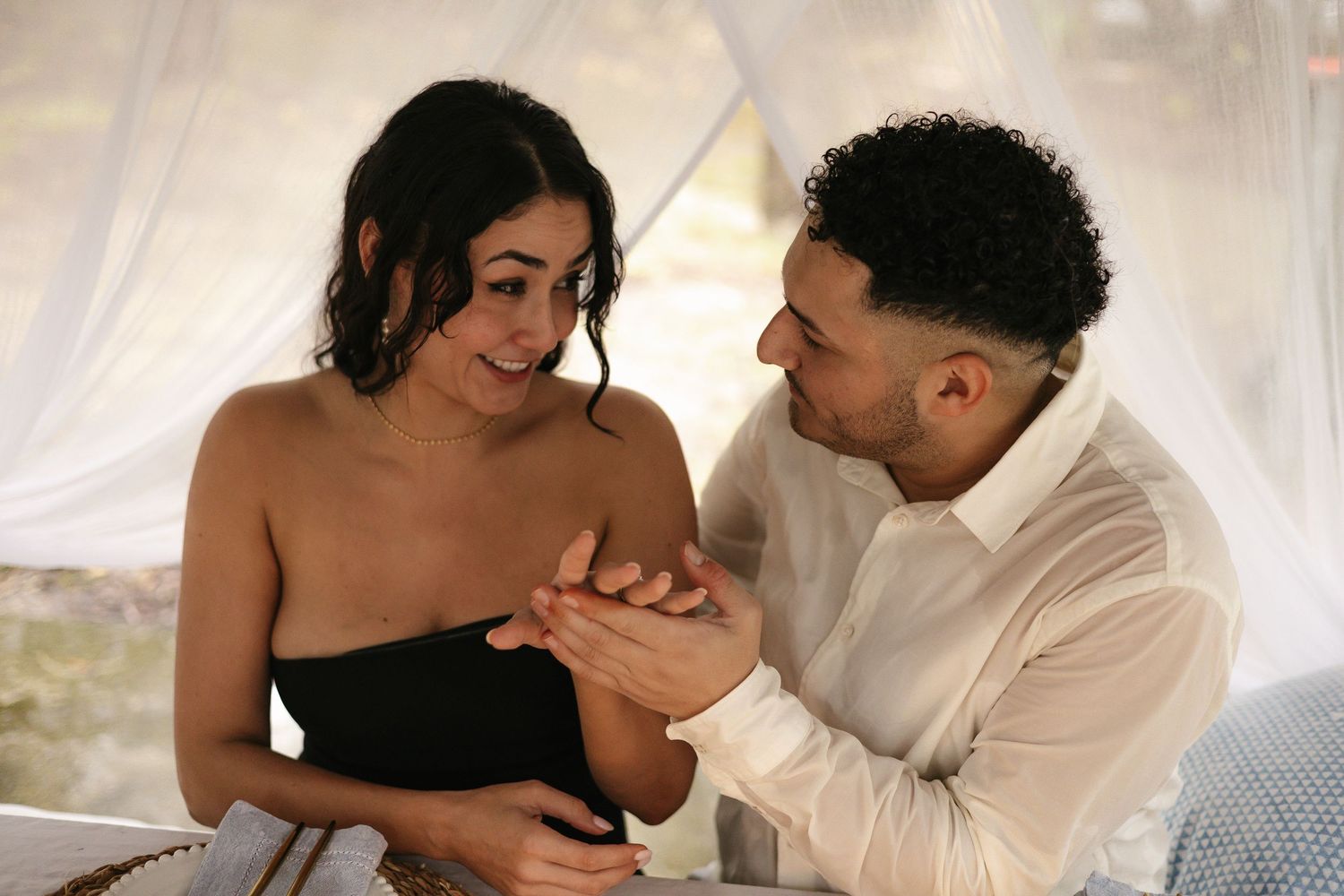 Couple sharing tender moments together during intimate photoshoot with white draping.