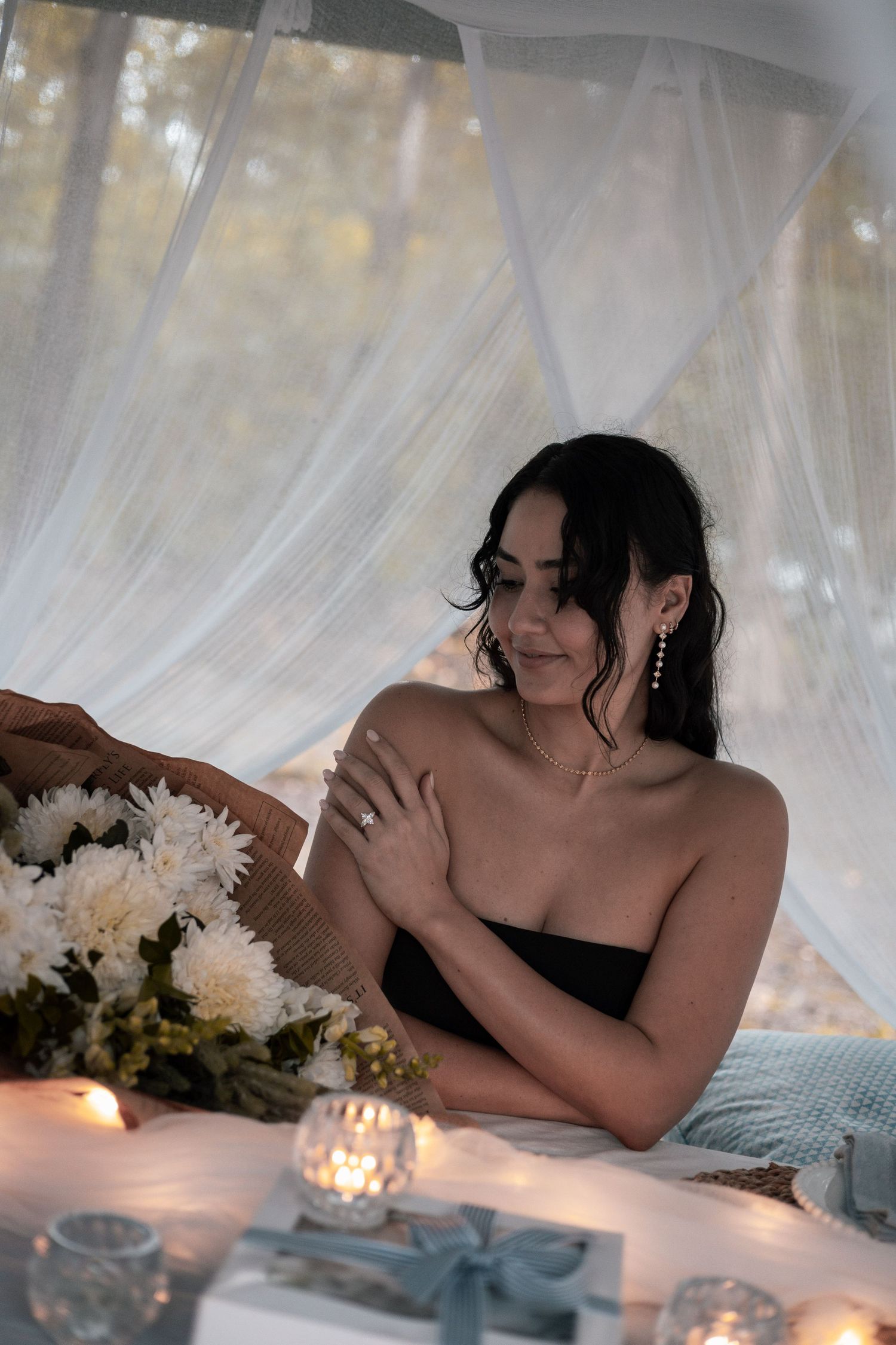 Romantic couple's portrait session with white flowers and candles creating ambiance.
