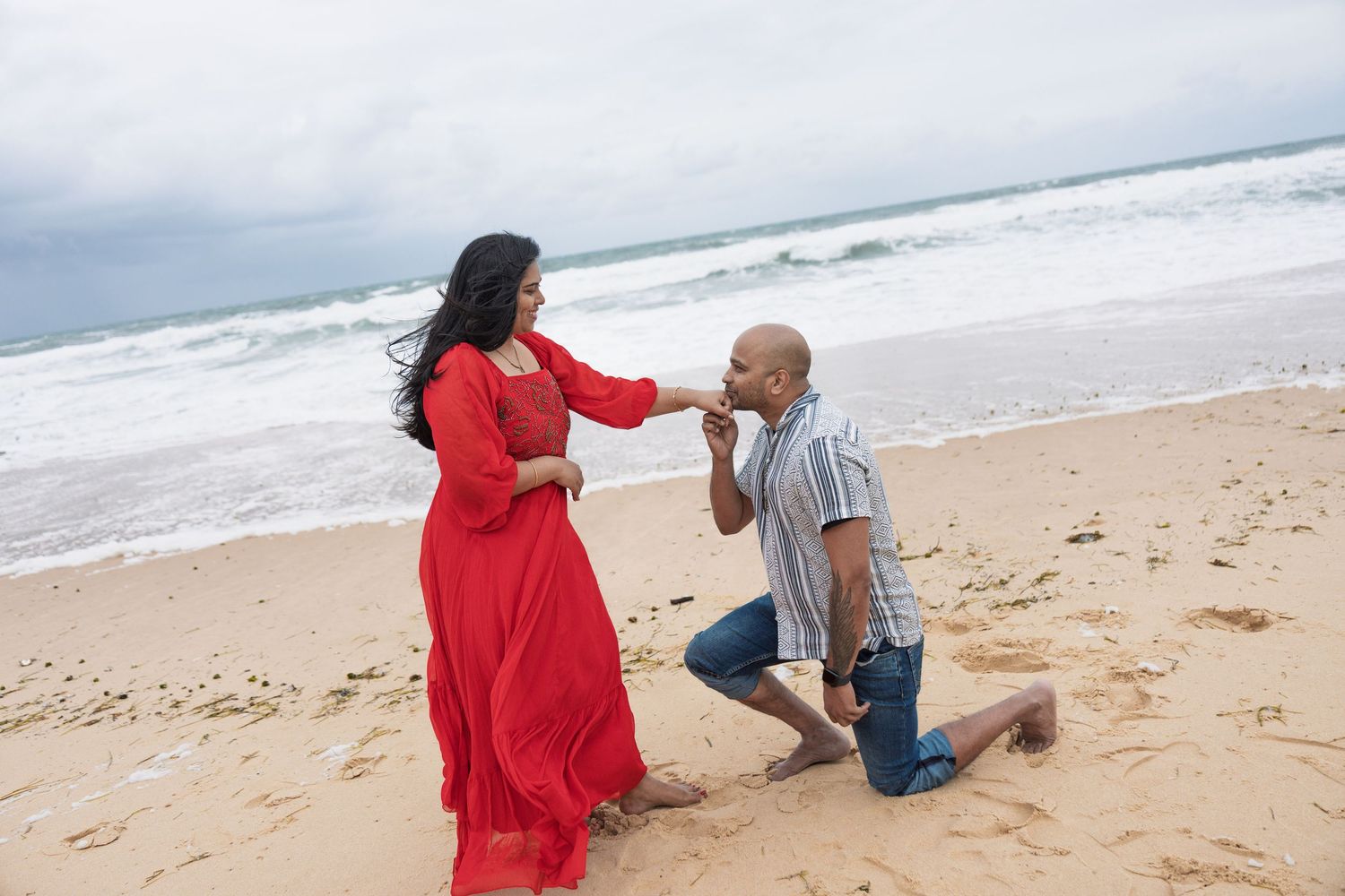 Engagement photoshoot sequence on sandy beach with ocean waves in background.