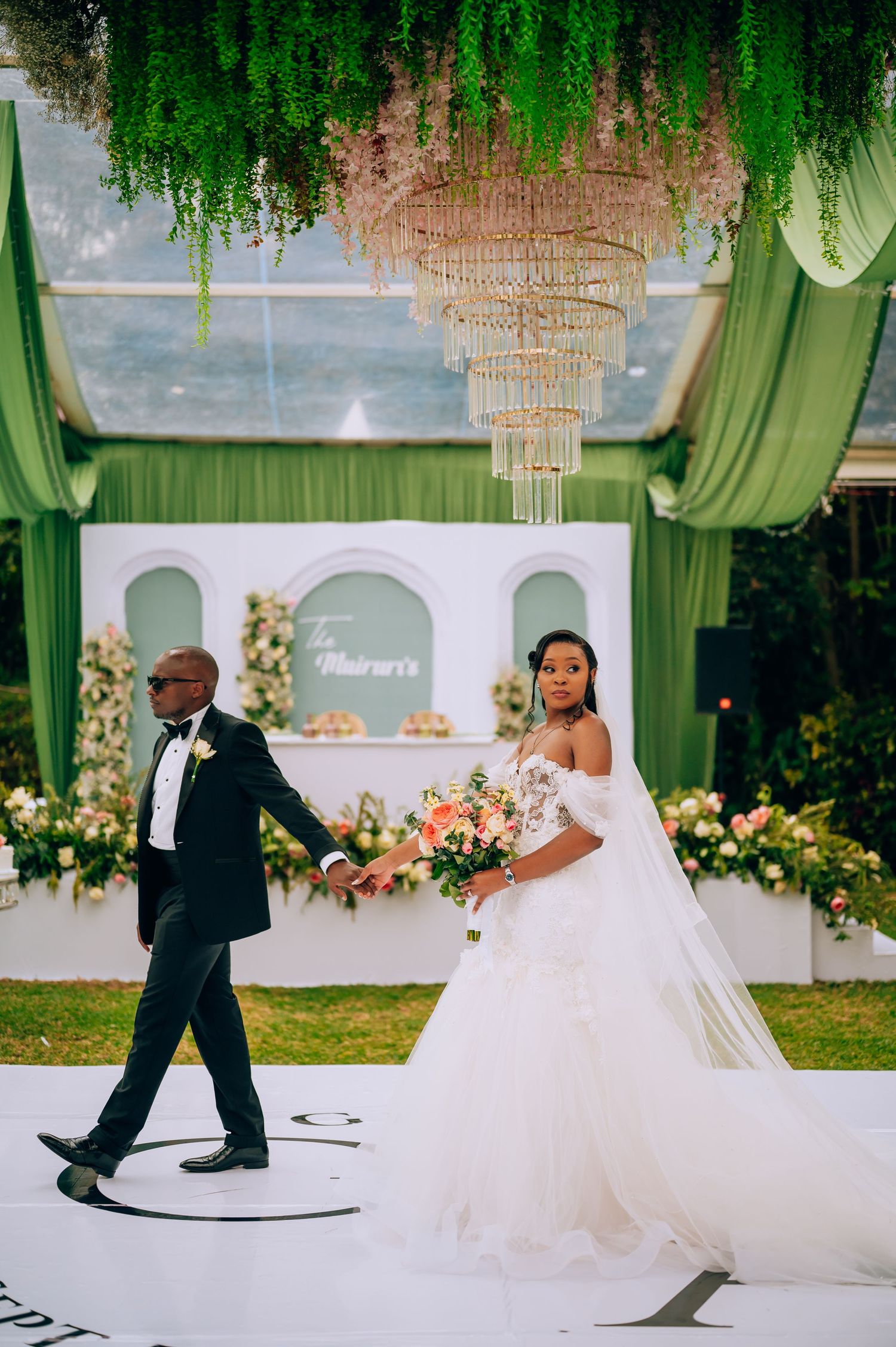 A wedding reception dance sequence with hanging greenery and floral decorations.