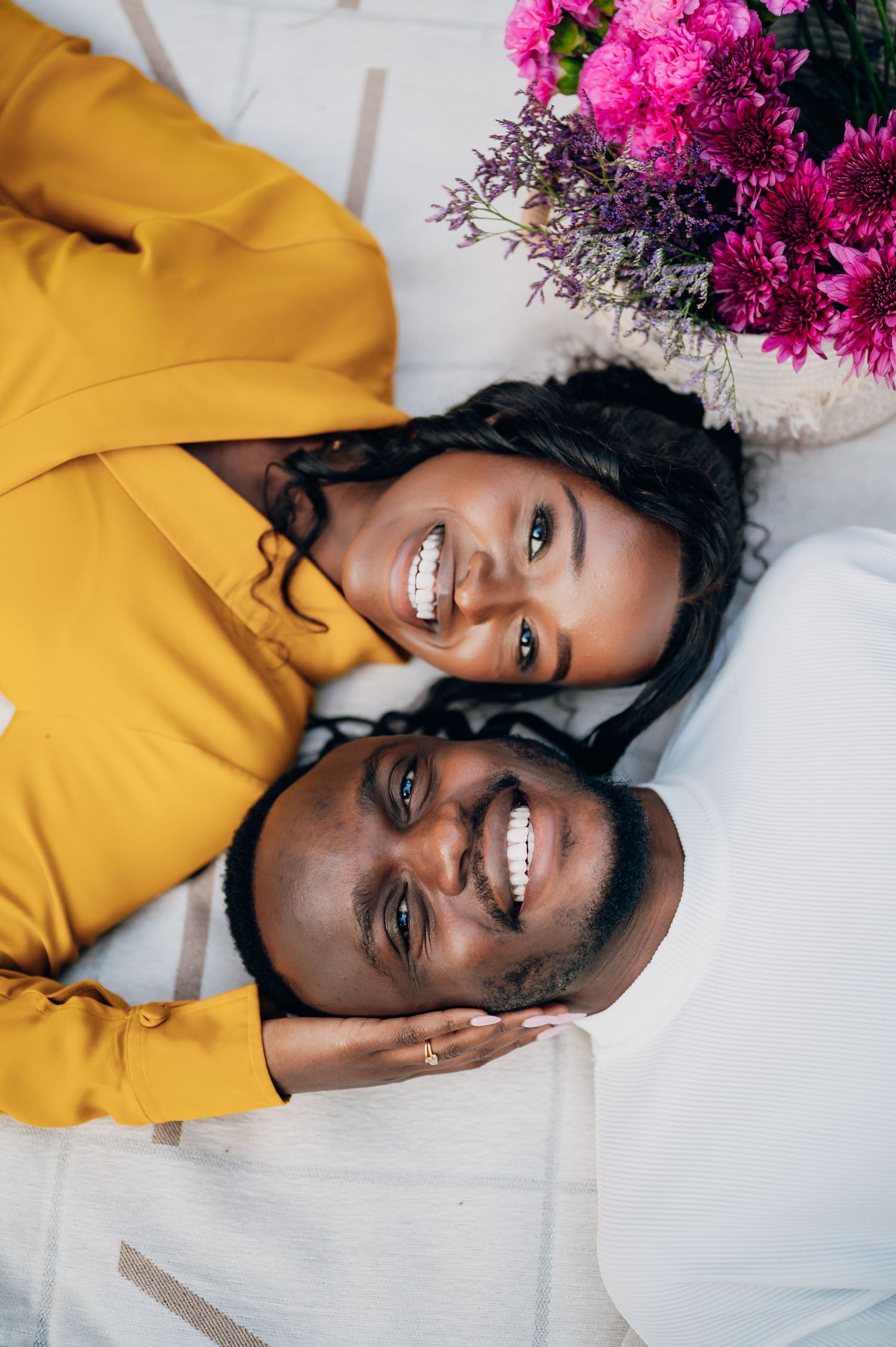 Portrait with vibrant pink flowers and a yellow sweater against a white background.