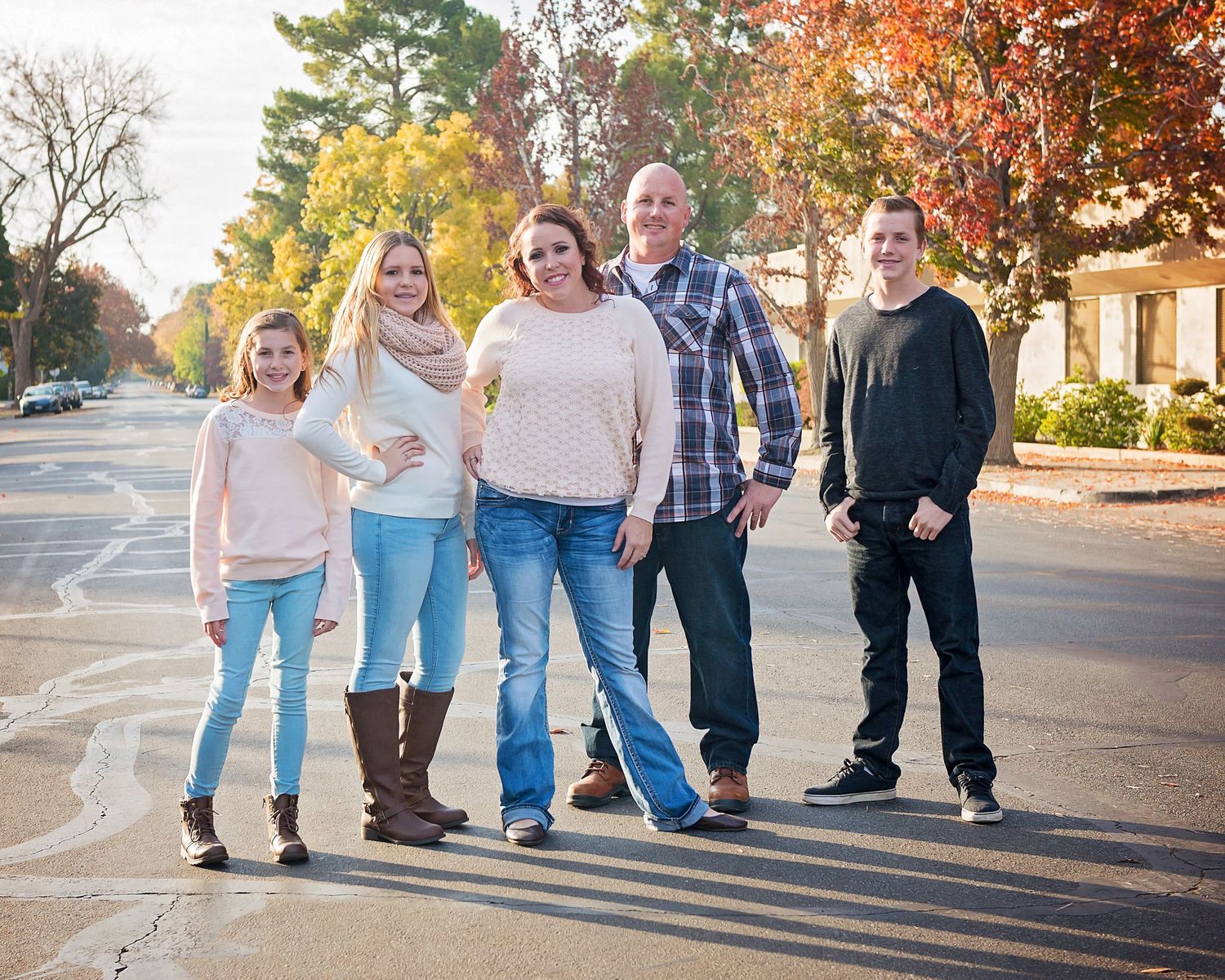 Family members walking together on a suburban street during golden hour.