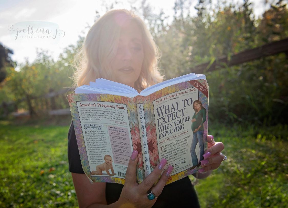 Person reading book outdoors during golden hour photoshoot.