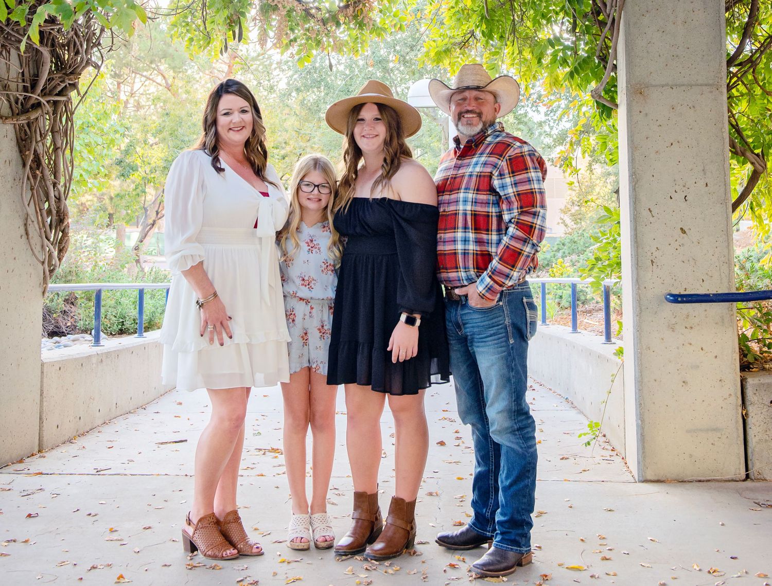 Family group portraits taken under covered walkway with natural light and greenery.