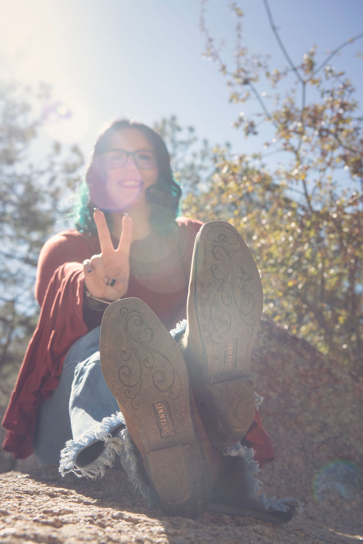 Sun flare illuminates boots with decorative details while lying down outdoors.