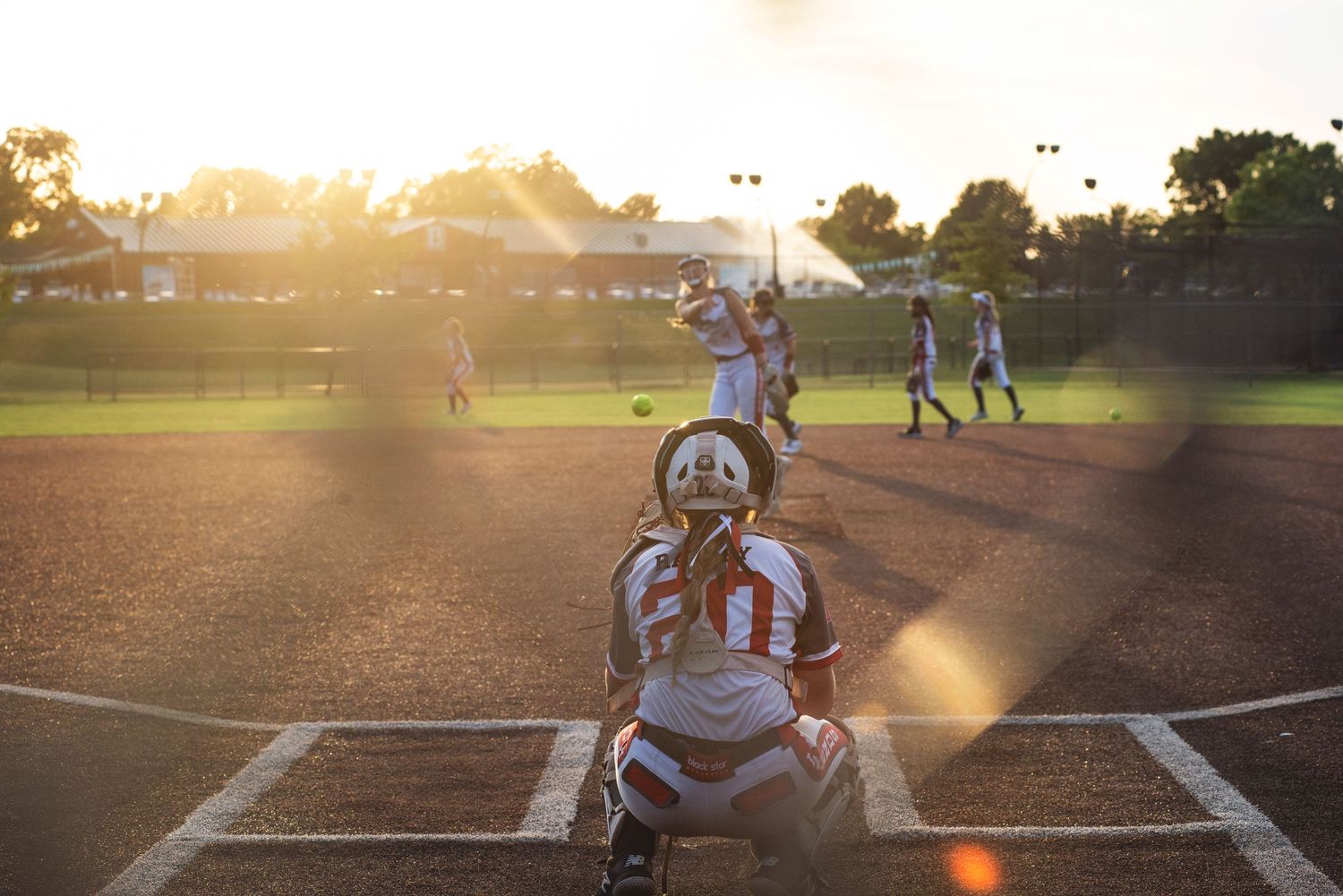 A baseball themed engagement photo shoot at sunset on a diamond field.
