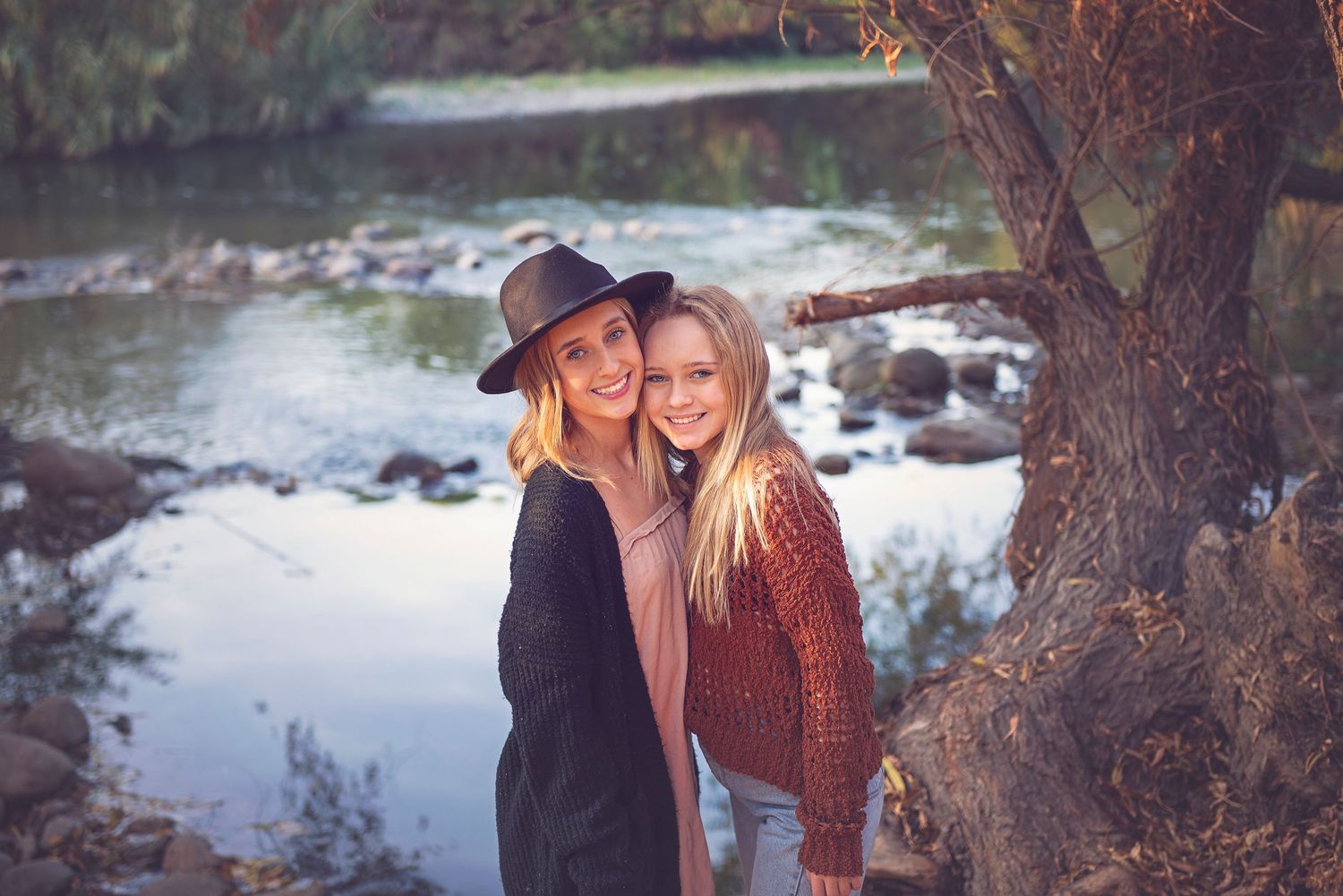 Couple enjoying an intimate moment in a natural outdoor setting during autumn.
