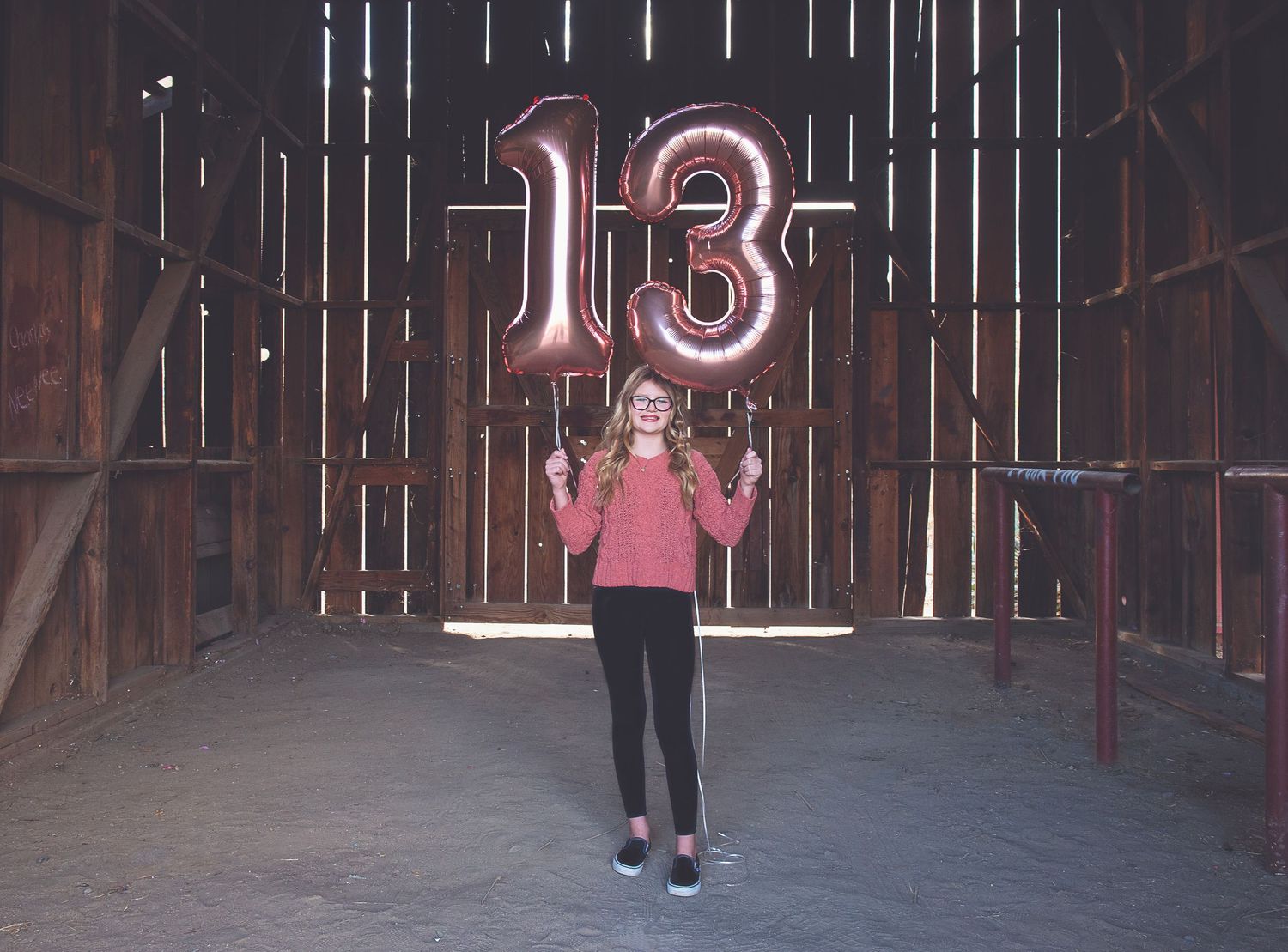 Rustic barn interior with glowing neon number 13 sign and person standing underneath.