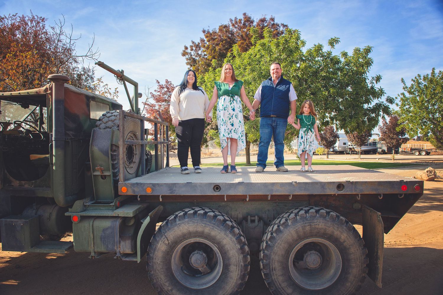 People standing on a large flatbed trailer during a sunny autumn day.