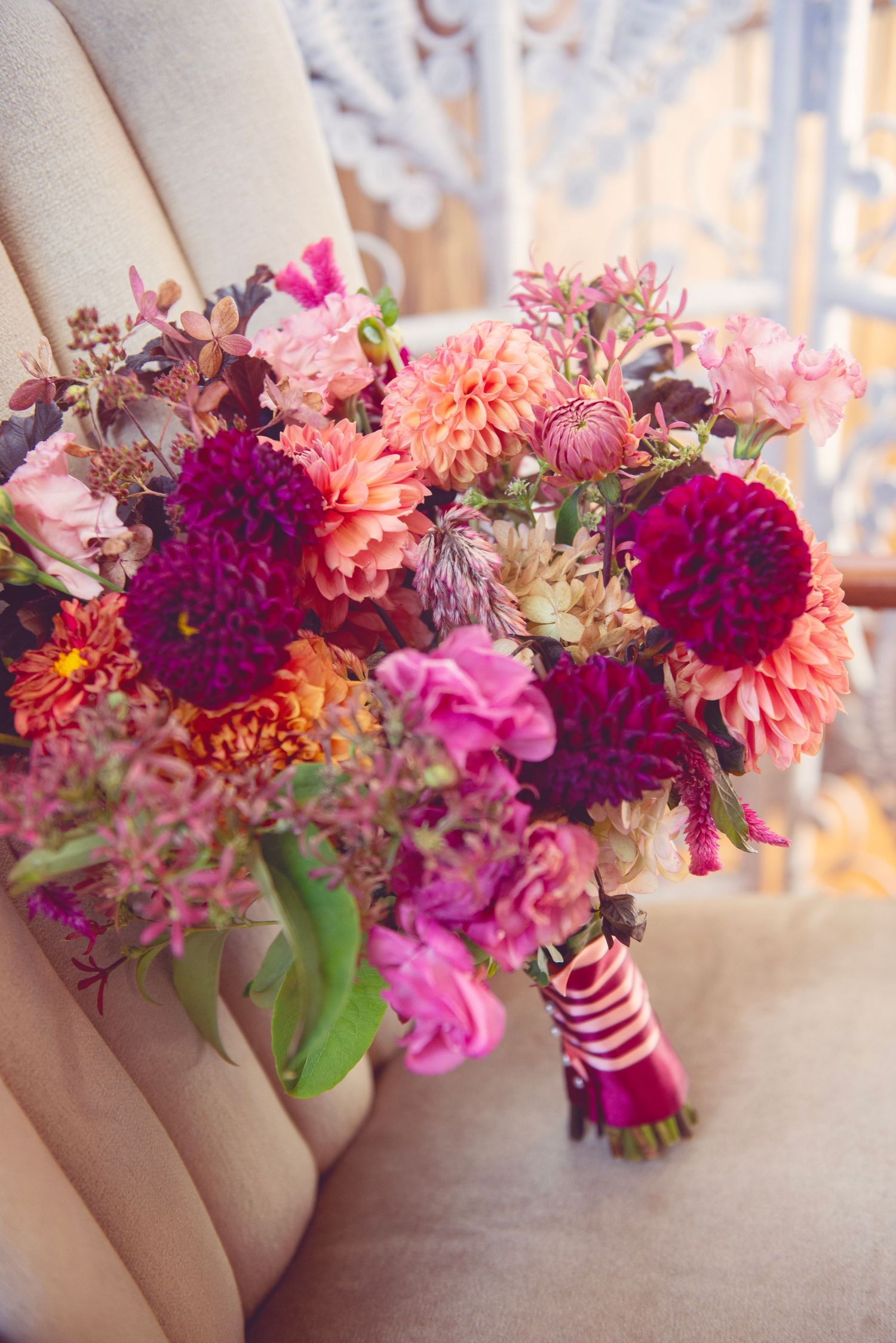 Vibrant bouquets of pink and purple dahlias with ribbons arranged in a row.