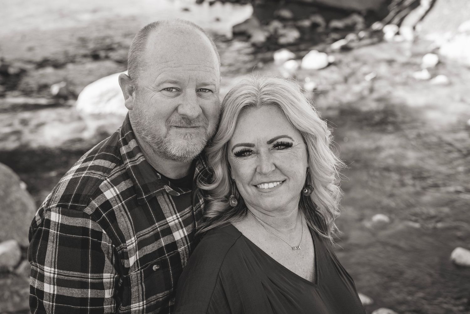 Couple poses together in snowy winter setting for outdoor portrait.