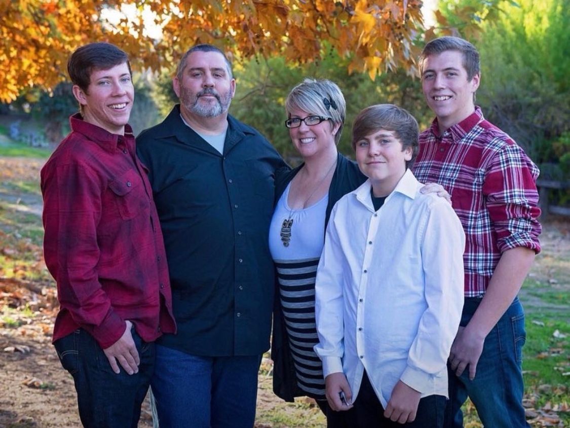 Family group portraits in coordinating burgundy and black outfits against autumn backdrop.