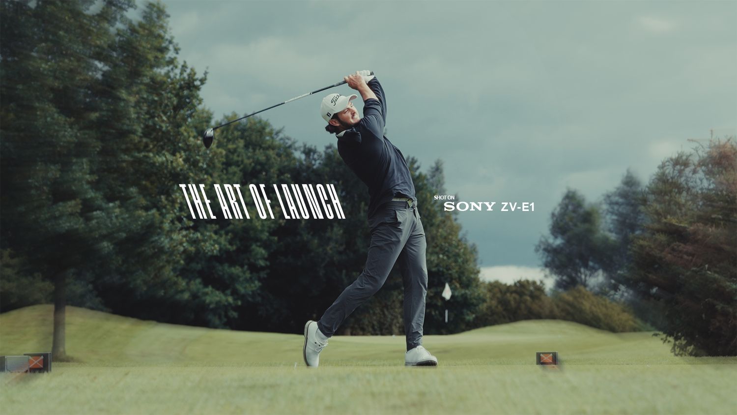 Golf players taking shots on a scenic course.