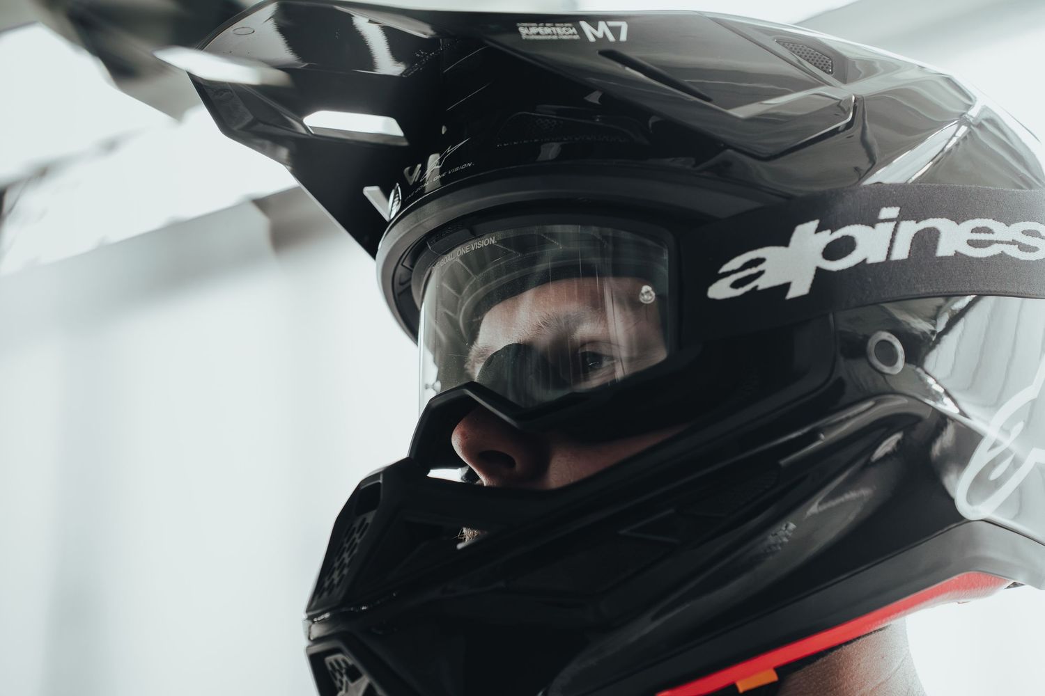 Person wearing a black Alpinestars M7 motocross helmet with clear goggles in a close-up shot.