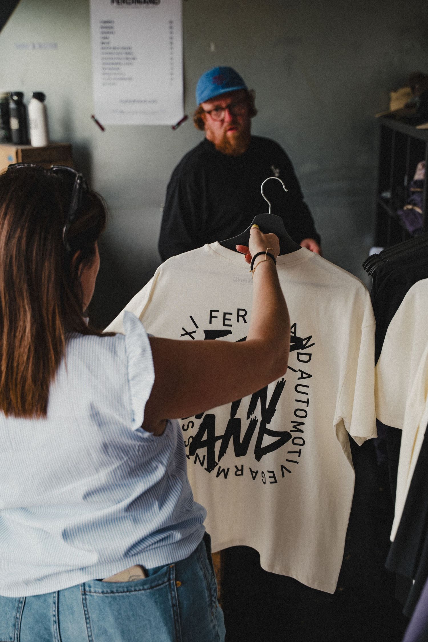 Retail merchandise interaction showing a t-shirt with brand design in a shop setting.