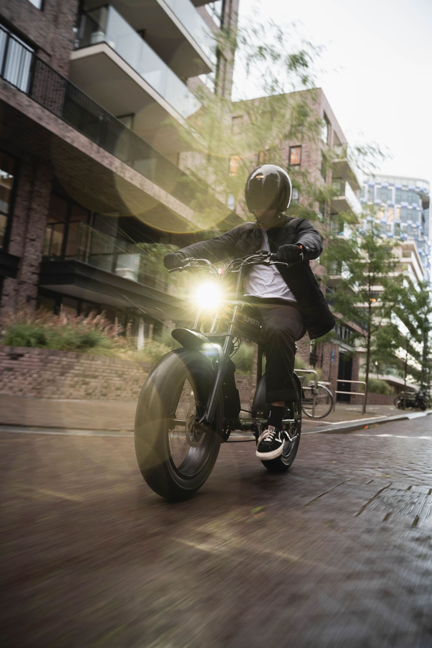 Motion-blurred shots of a custom motorcycle cruising through an urban apartment complex.
