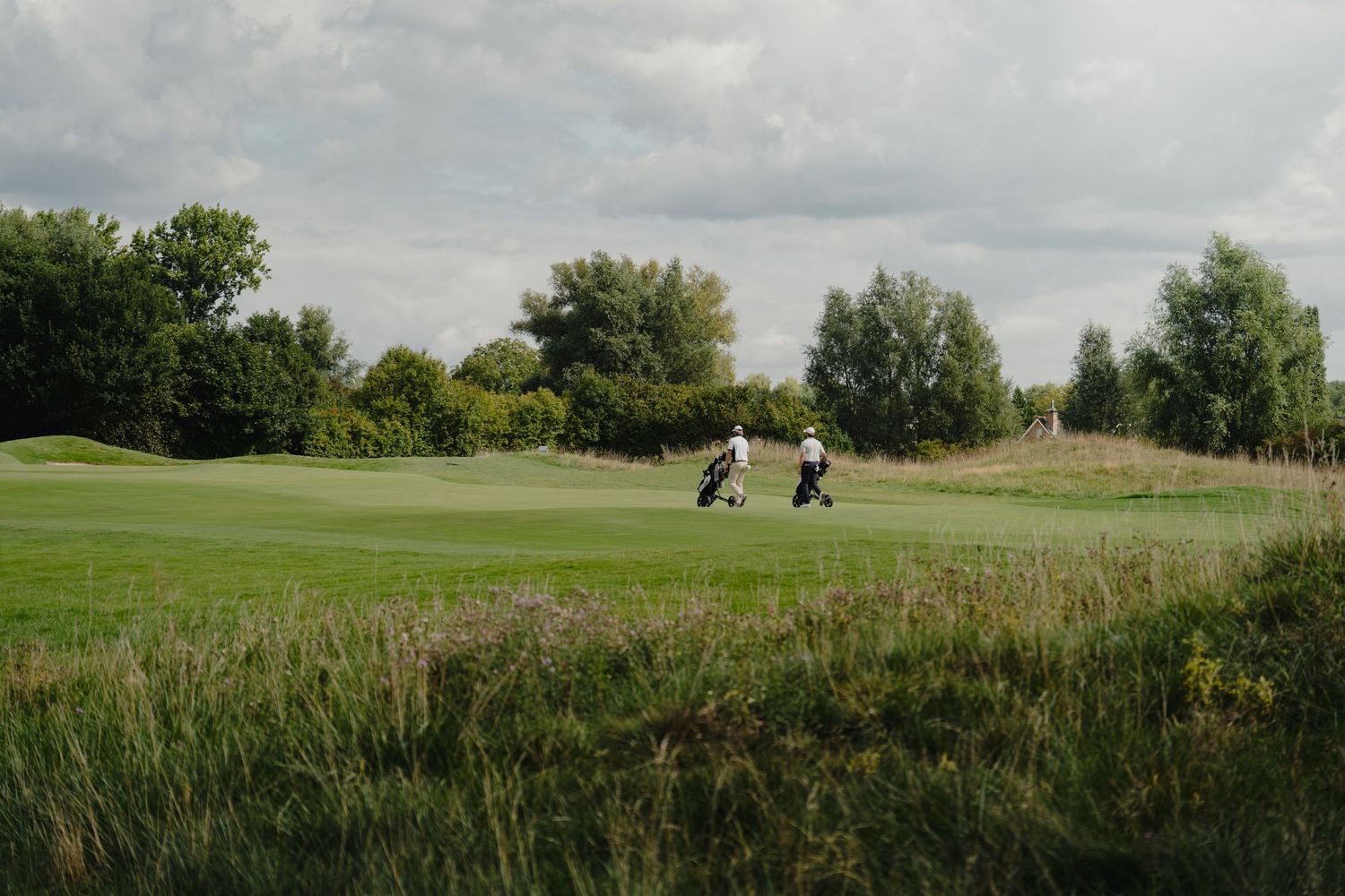 Panoramic landscape of a golf course showing rolling fairways and natural vegetation.