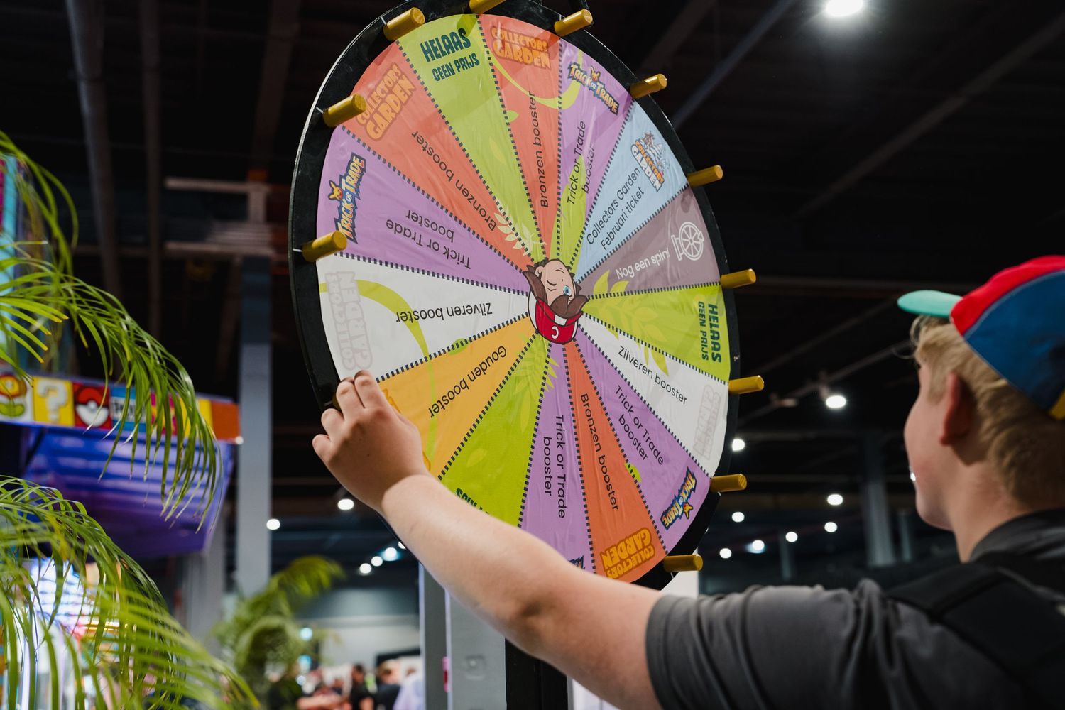A child spins a colorful prize wheel at an indoor event or trade show exhibition.