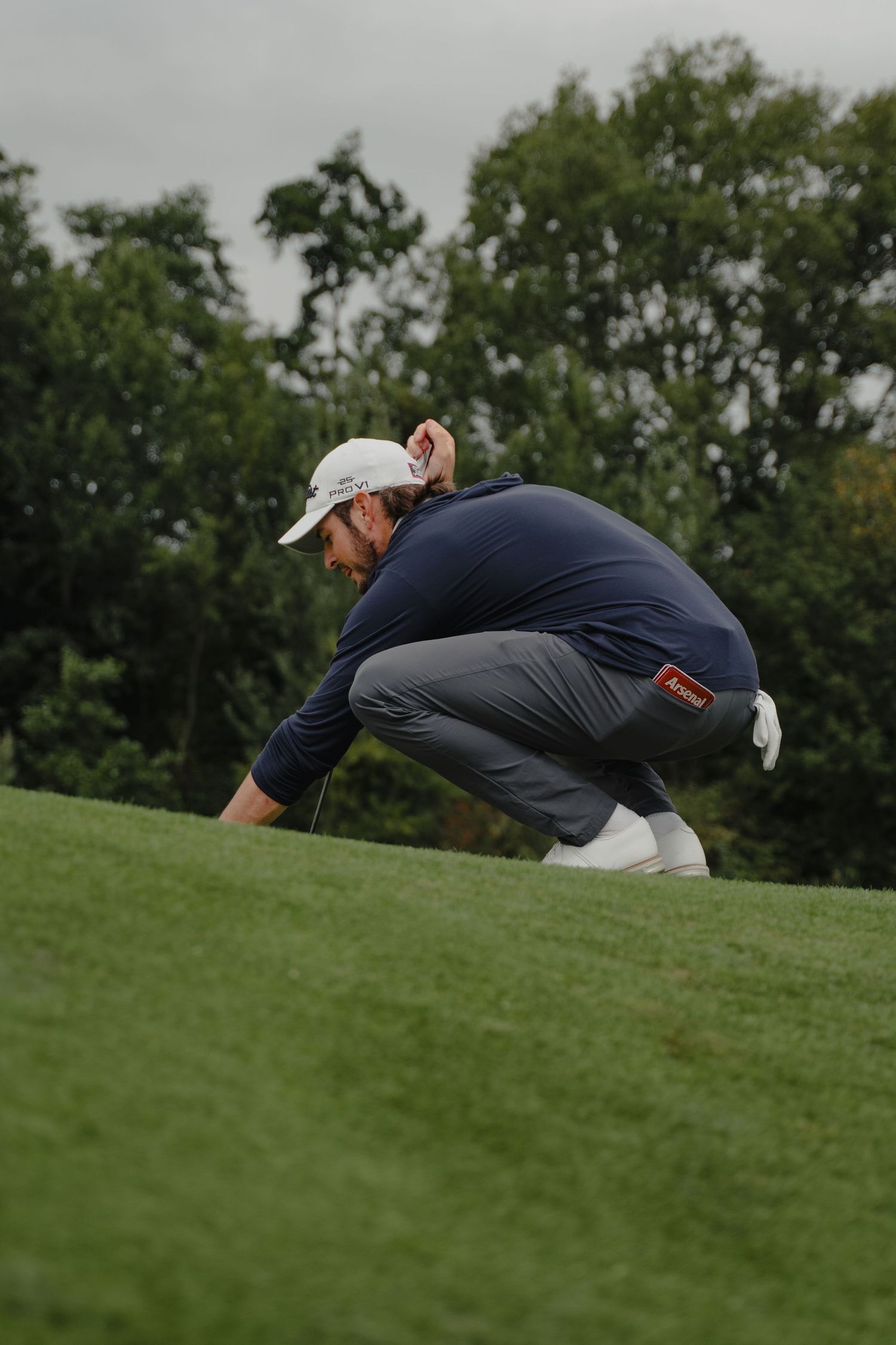 Sequence showing a golfer analyzing the slope of a putting green from different angles.
