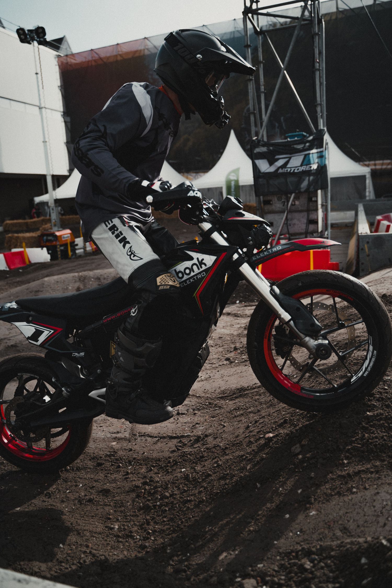 Dirt bike rider navigating a muddy track during a motorsport event.