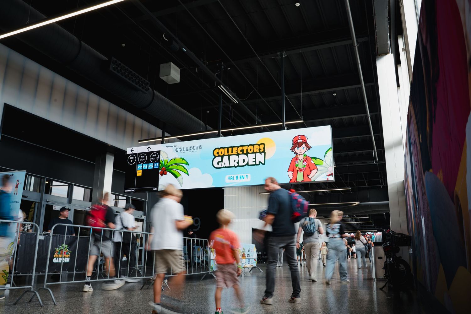 Collectors Garden event entrance with a large LED sign, attendees walking through a modern convention center lobby.
