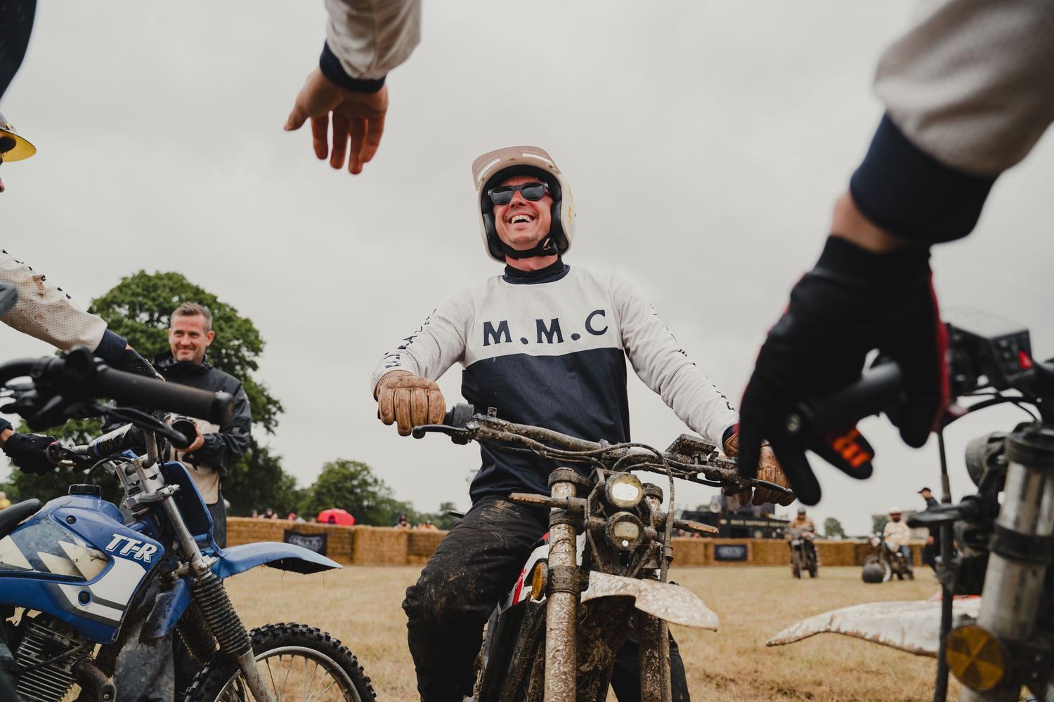 Group of motorcycle riders gathered on a dirt track before a race.