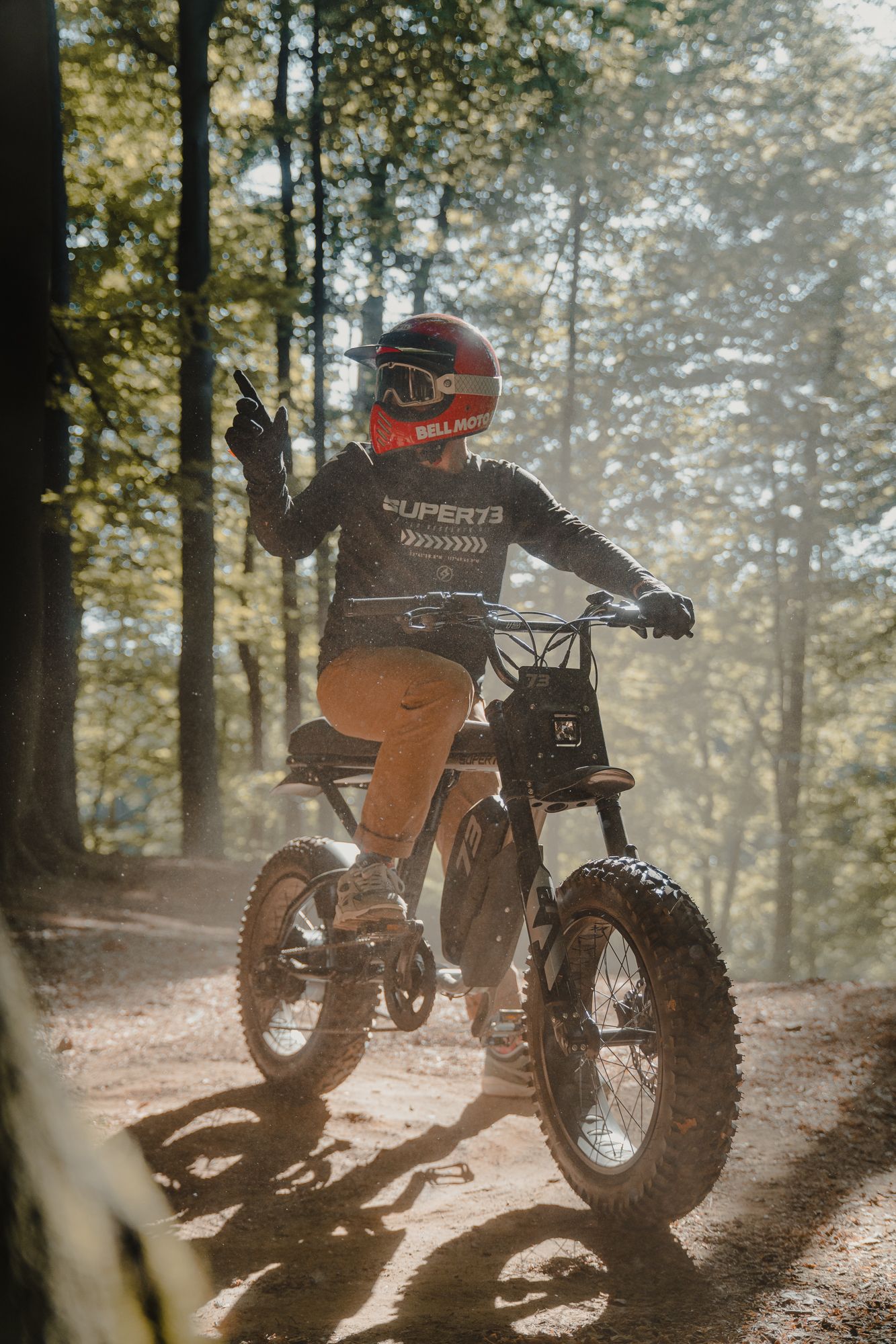 A dirt bike rider navigates through a misty forest trail on a rugged off-road motorcycle.