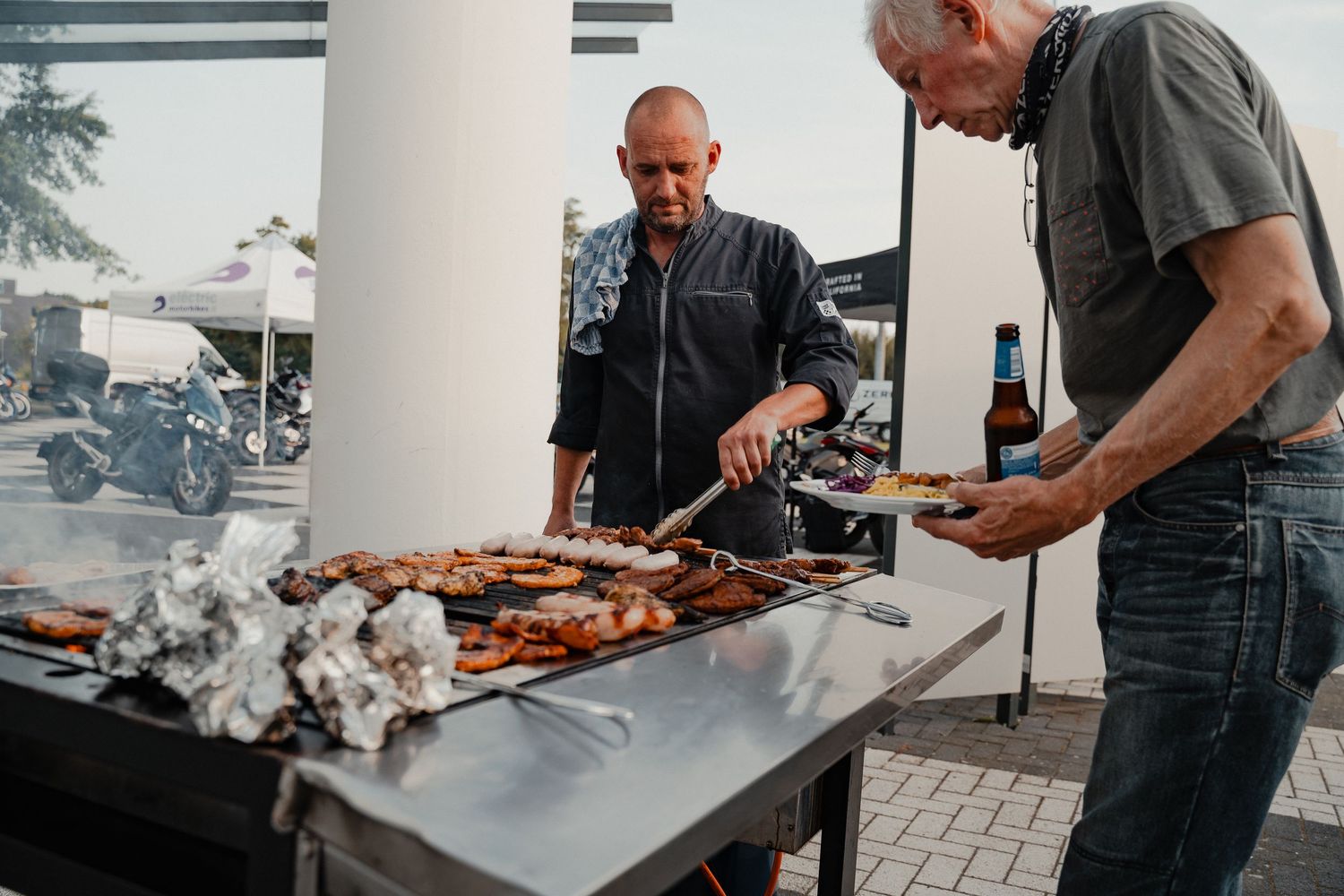 Food preparation and grilling station at an outdoor motorcycle event.