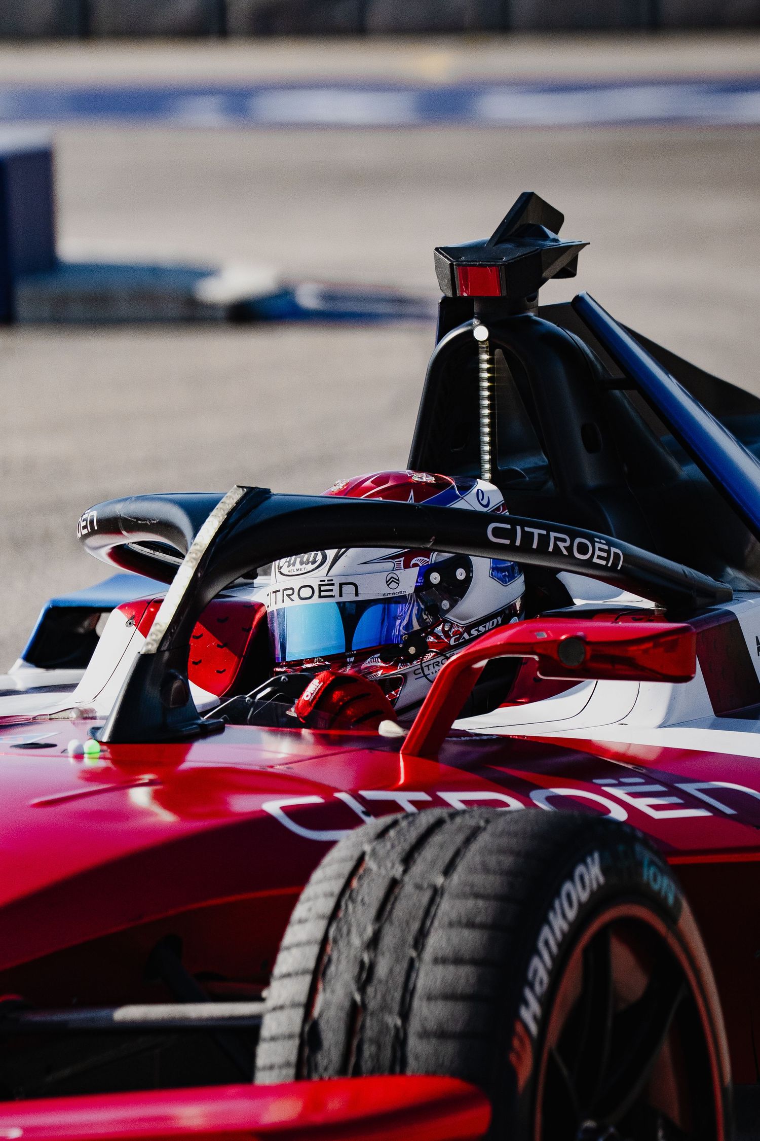 Citroën Formula E racing car with driver in helmet navigating a street circuit track.