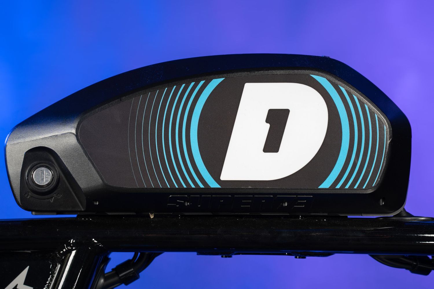 Close-up of sleek black and blue electric bike display panel with 'D' branding.