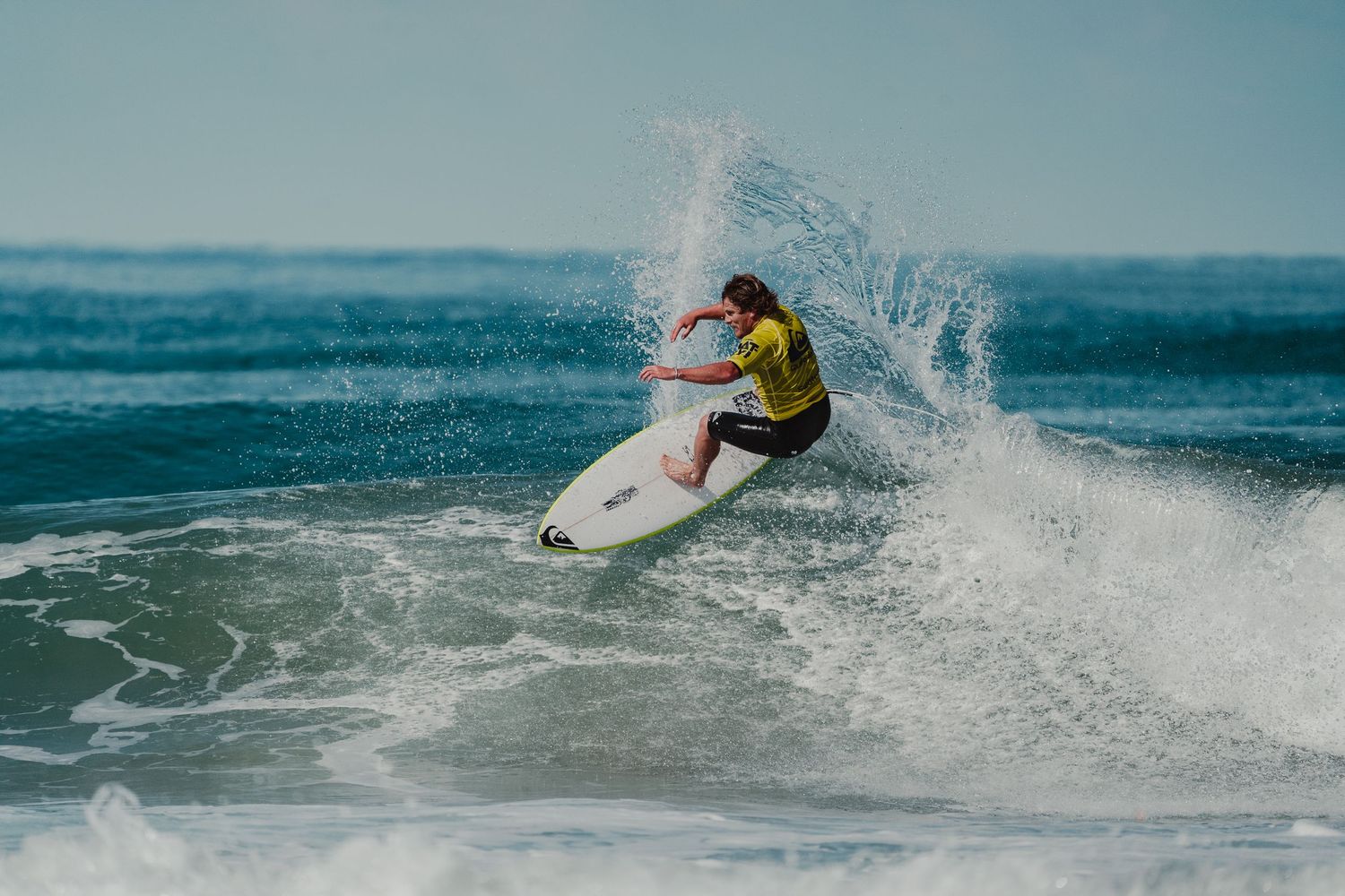 Dynamic surfing sequence showing multiple riders performing tricks on ocean waves.