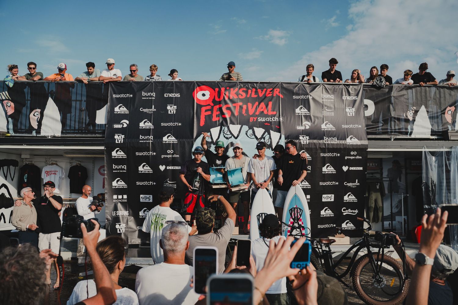 Crowd of spectators watching action sports competition from behind barriers at an outdoor venue.