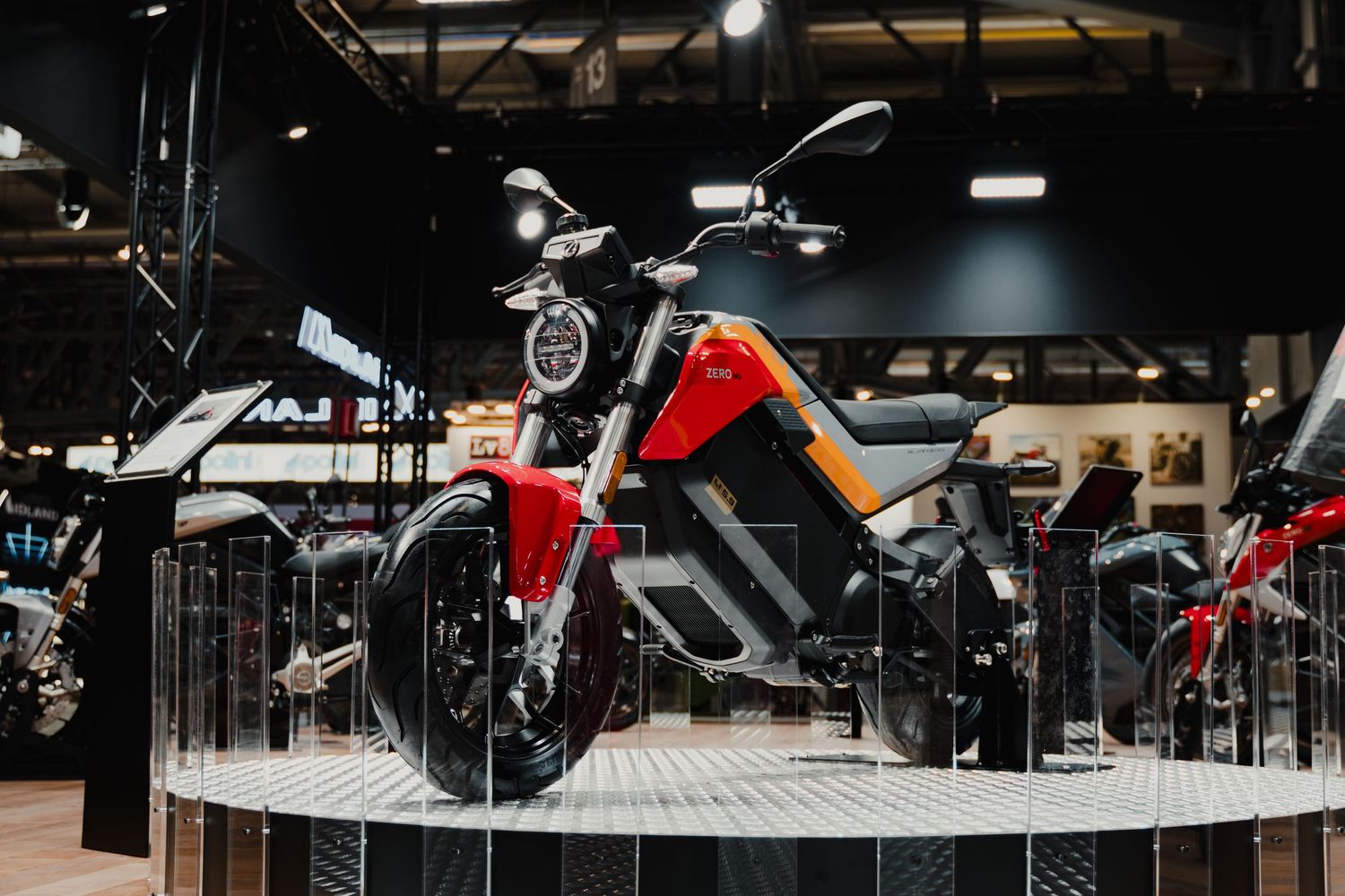 Dark showroom interior featuring multiple motorcycles on display with dramatic lighting.