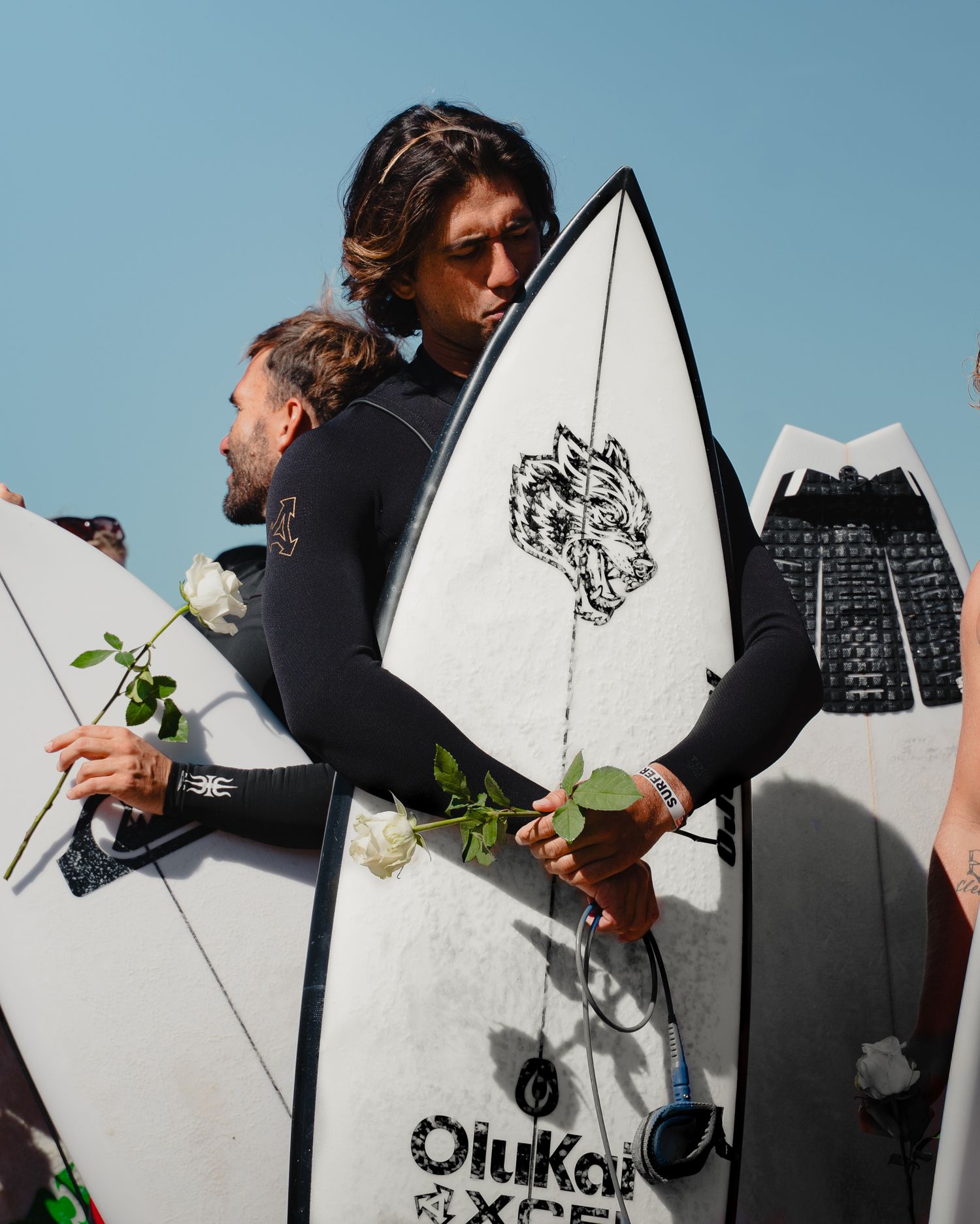 Close-up of surfboards with logos lined up against blue sky background.