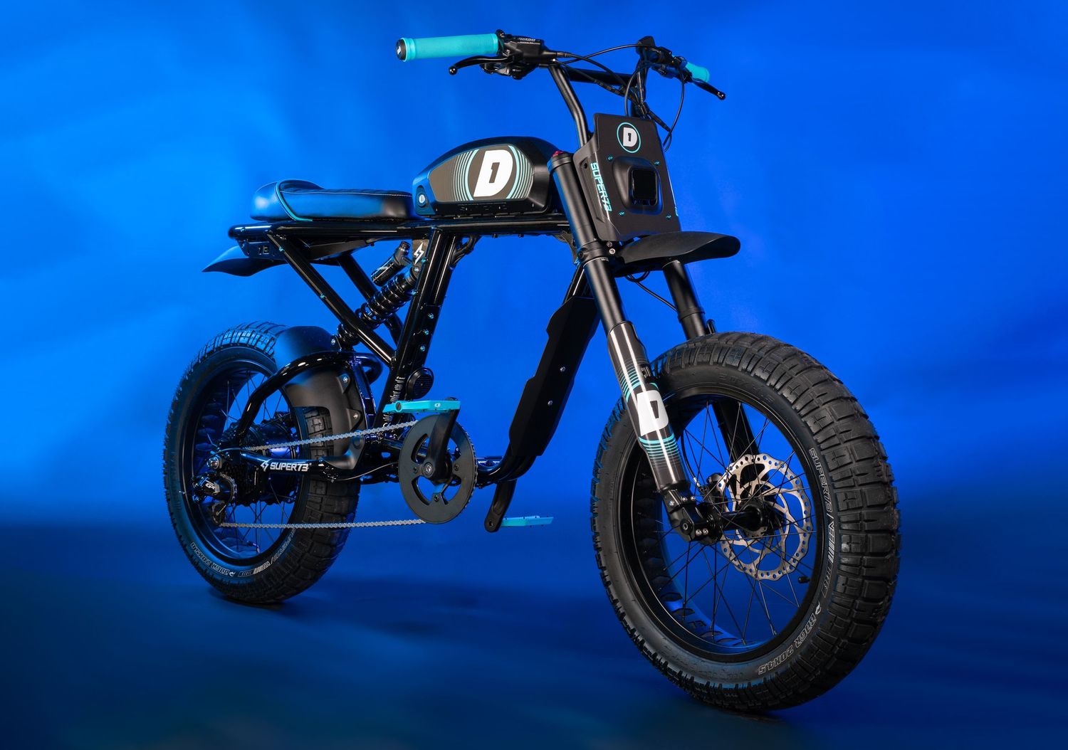 Custom electric motorcycle with black frame and chunky tires against blue background.