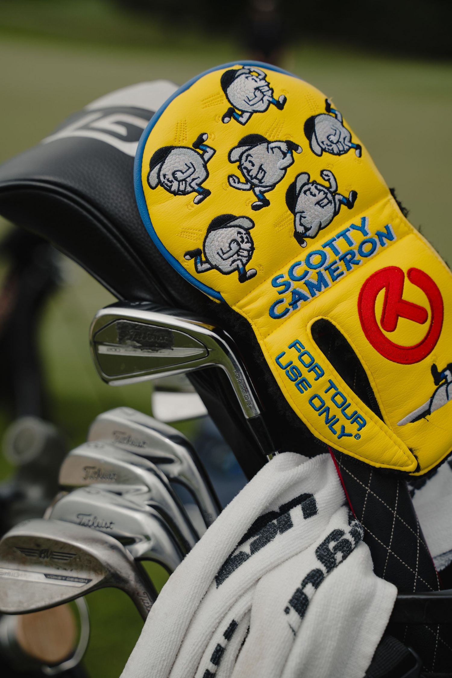 Golf club headcovers featuring cartoon character designs in yellow and blue.