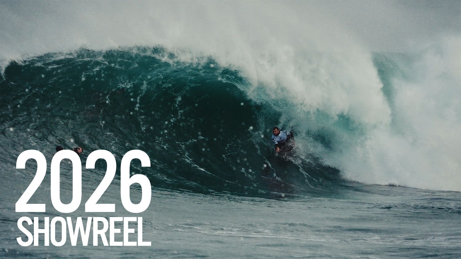 Large ocean wave crashes and curls during a dramatic surfing showreel sequence in stormy conditions.