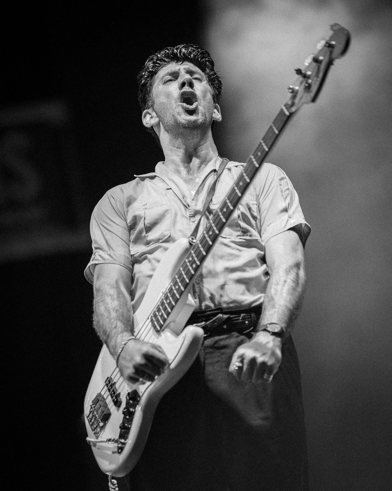 A musical artist showing strong emotions of excitement with a guitar.