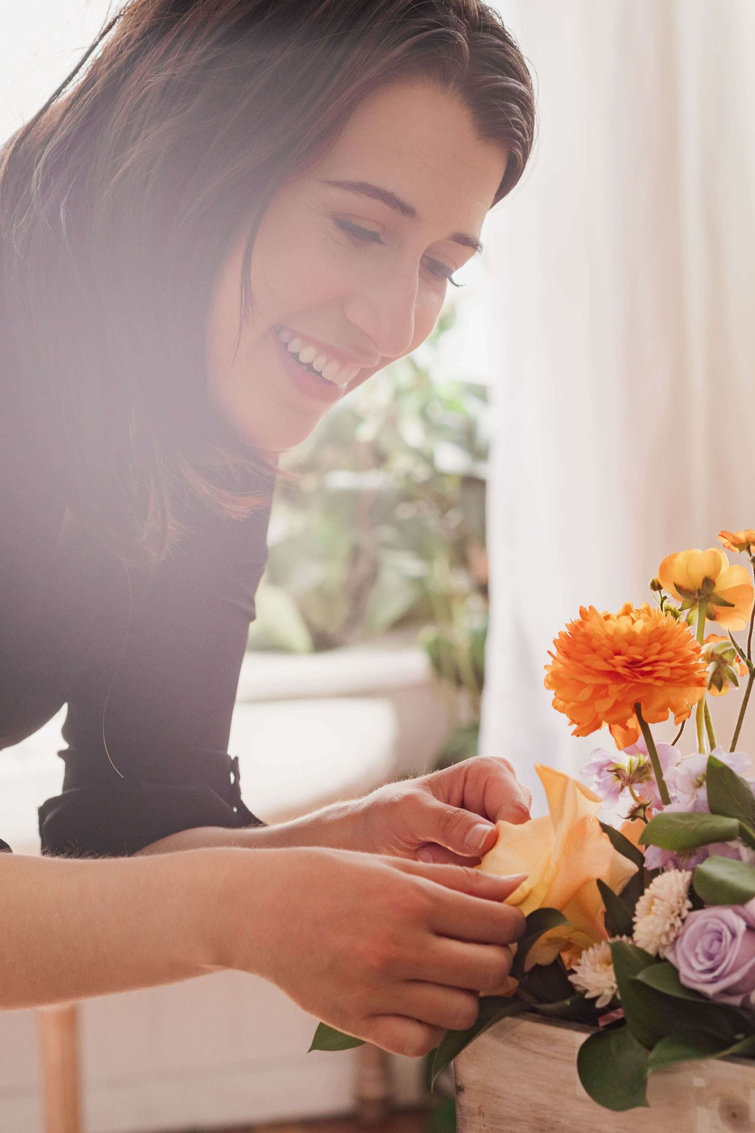 Florist adjusting flowers in a planter box arrangement